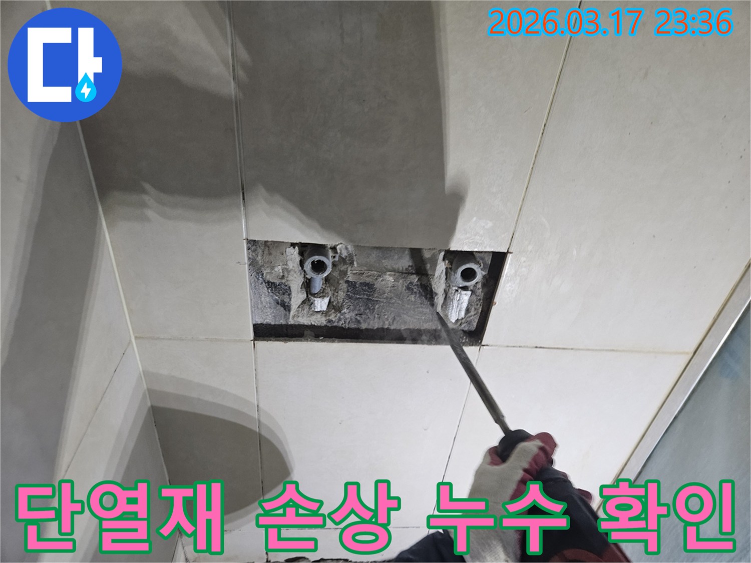 숙련된 기술자가-누수 탐지 후-타일 아래 숨은-벽면 내부 단열재의-손상 여부를-드러내고-확인하는 작업
