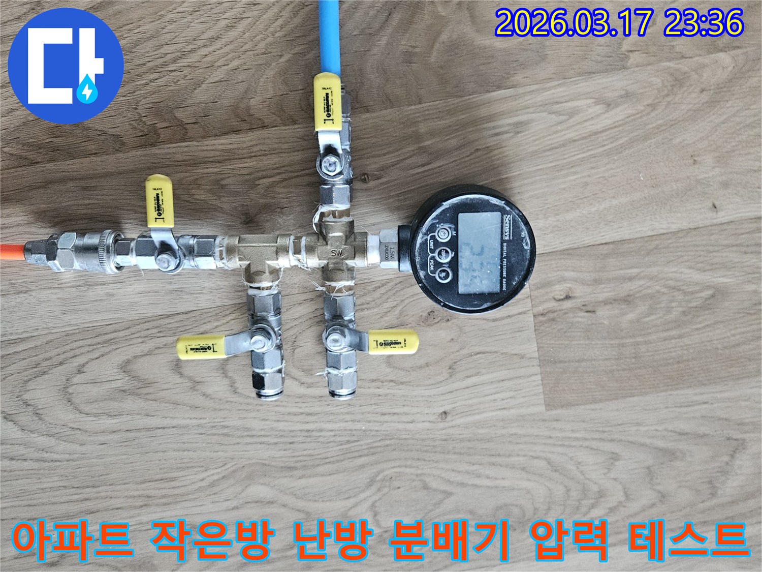 아파트 작은방 난방 분배기의 누수 여부를 확인하기 위해-전문 압력 테스트 장비를 연결하여-정밀하게 검사하고 있습니다.
