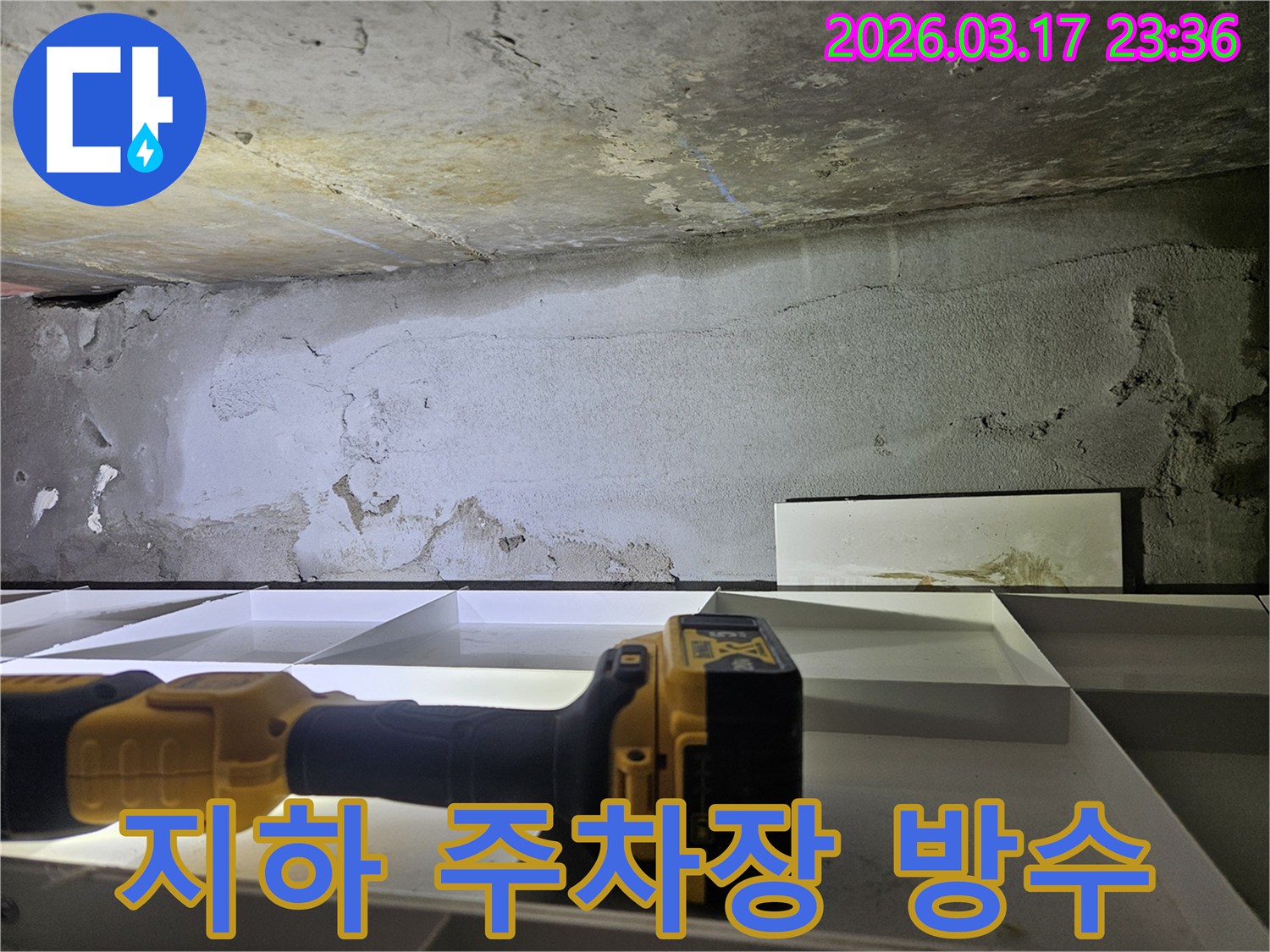 전문 엔지니어가-지하 공간의 젖은 벽면을-정밀 탐지 장비로 확인하며-주차장 누수 원인을 분석하고 있습니다.