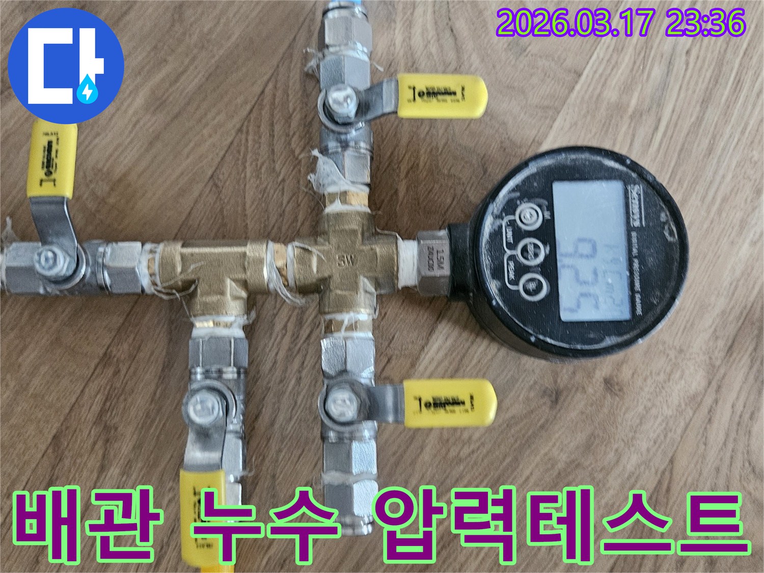전문가가 배관에 연결된 압력 게이지로-누수 지점을 파악하기 위해-압력 변화를 측정하고 있습니다
