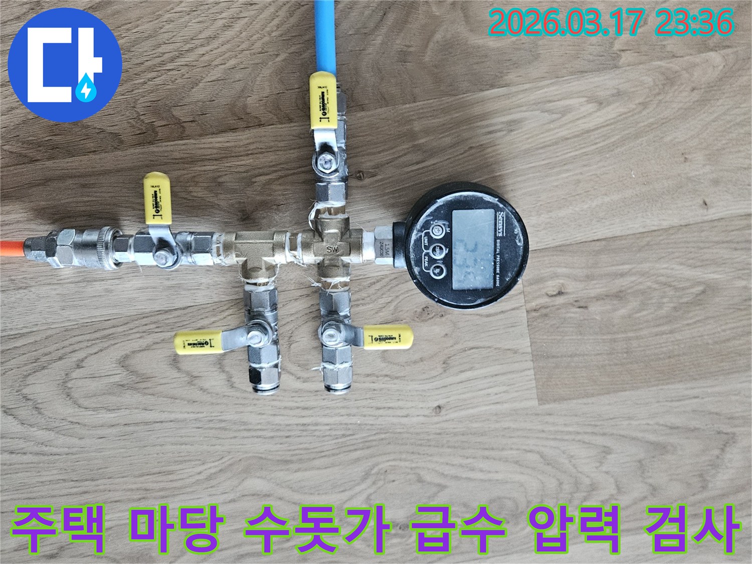 주택 마당 수돗가 급수 배관의 누수 여부를 확인하기 위해-정밀한 압력 테스트 장비를 연결하여-수치를 측정하고 있습니다.