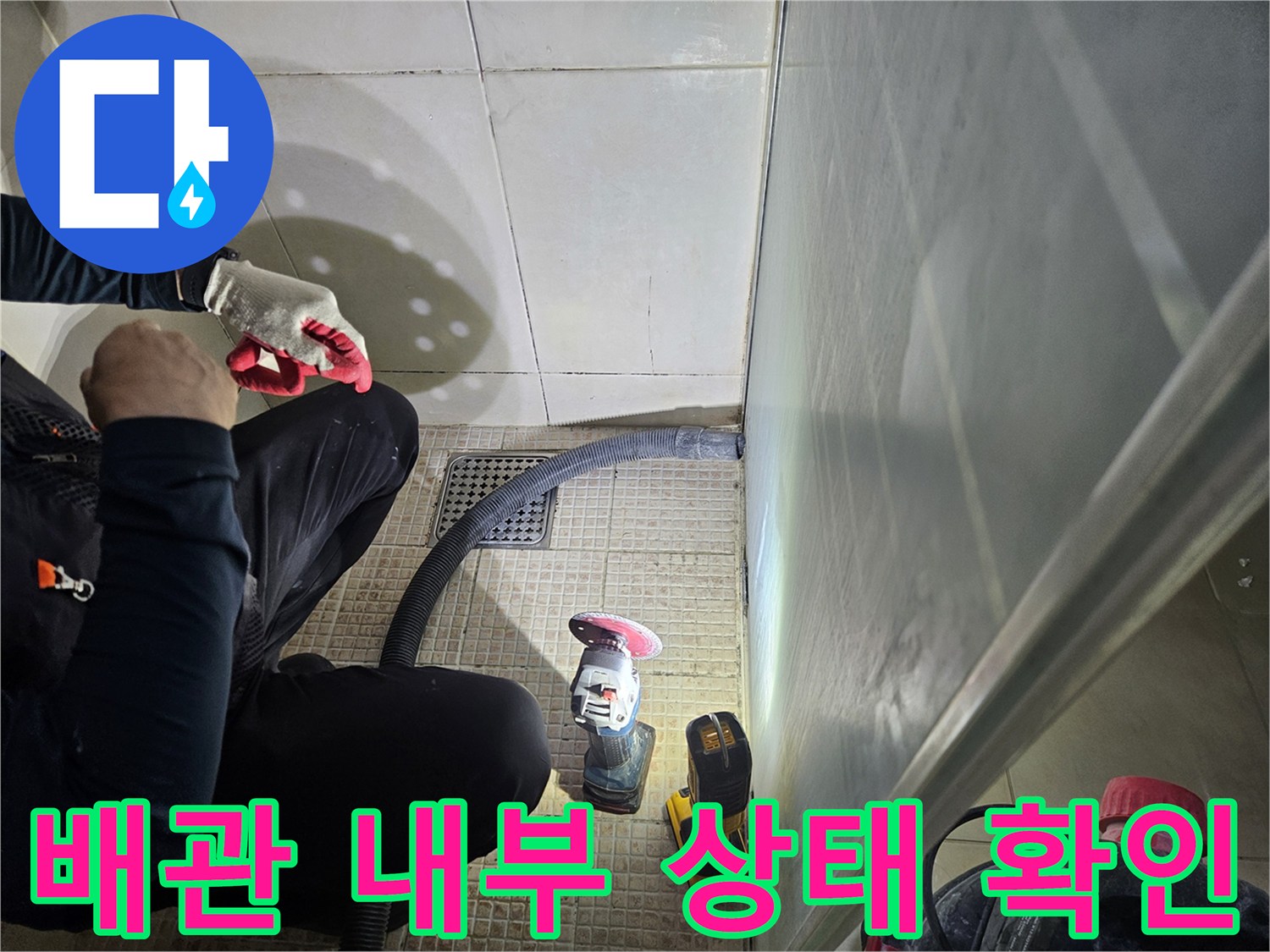타일 틈새로 연결된 검사용 호스와 현장 도구들