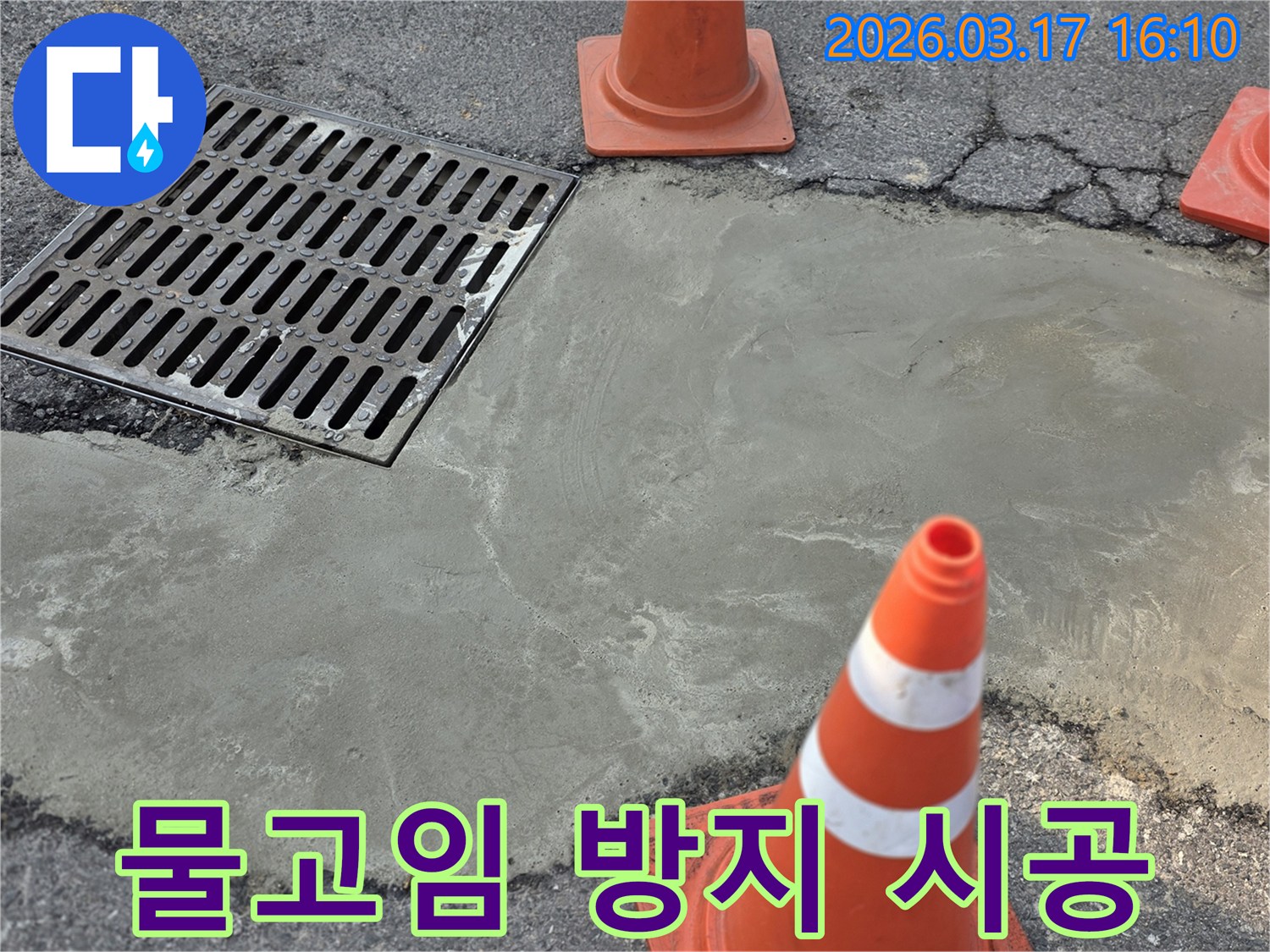 이 이미지는 양주 율정동의 외부 바닥 누수 문제로 인한 물고임 방지 시공이 완료된 상태를 보여주며-새로운 시멘트 마감과 안전 콘이 놓여 있습니다.
