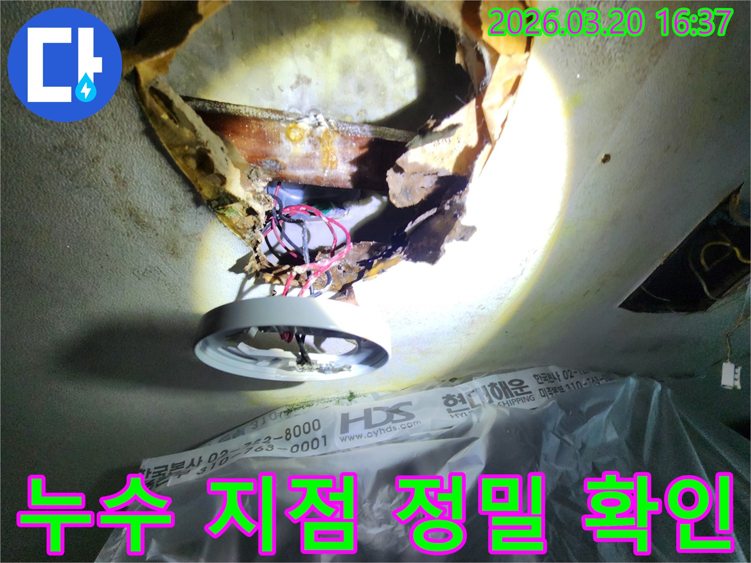천장 누수-현장에서-부식된-천장 마감재와-노출된-배관을-조명으로-확대하여-점검하는-모습입니다