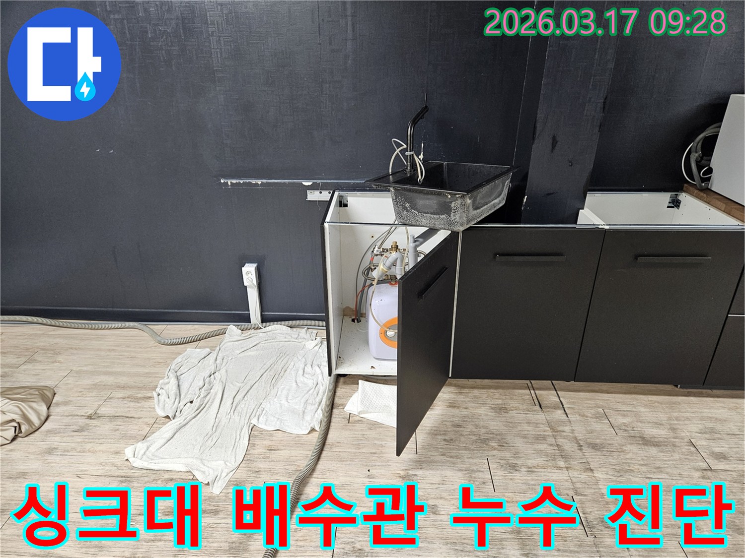 싱크대 아래 배수관과 수도 연결 부위를-누수 여부를 확인하며 면밀히 점검하는 모습
