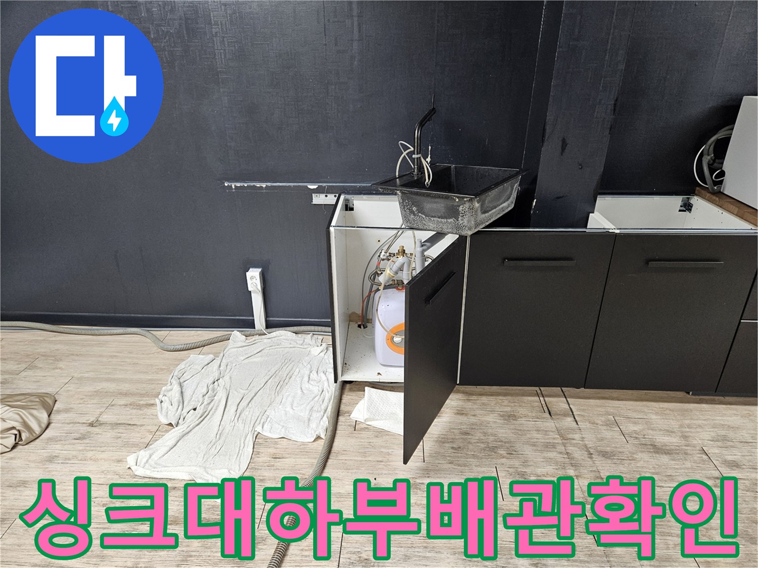 싱크대-아래쪽-열린-공간에-보이는-온수기와-주변-배관의-상태