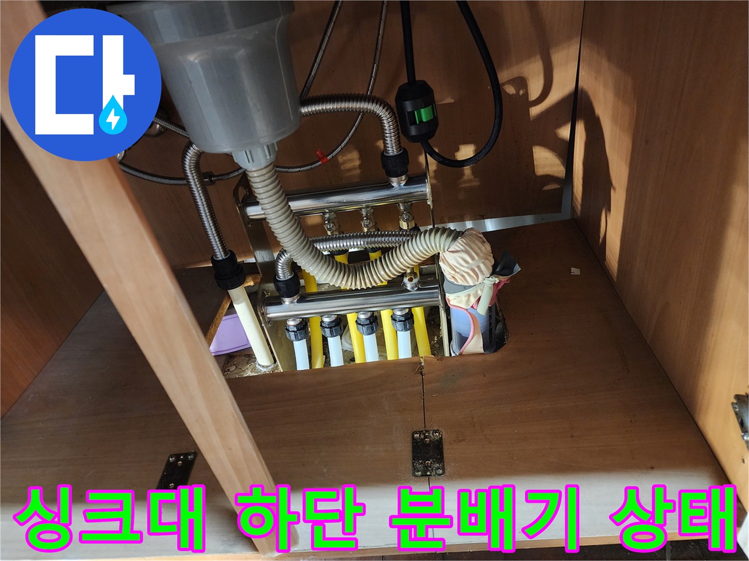 파주 금촌동 현장-싱크대 아래 노출된 난방 분배기와 배관 연결 부위 모습