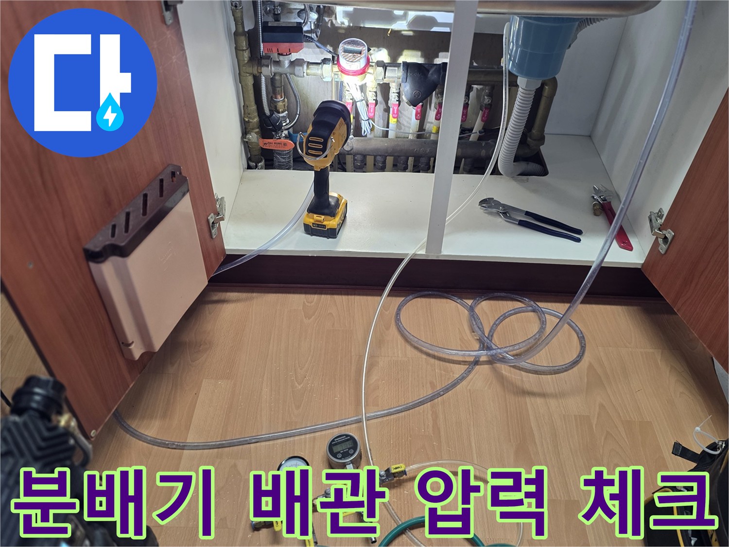 싱크대 하단 분배기에 연결된 공압 테스트용 게이지 장비