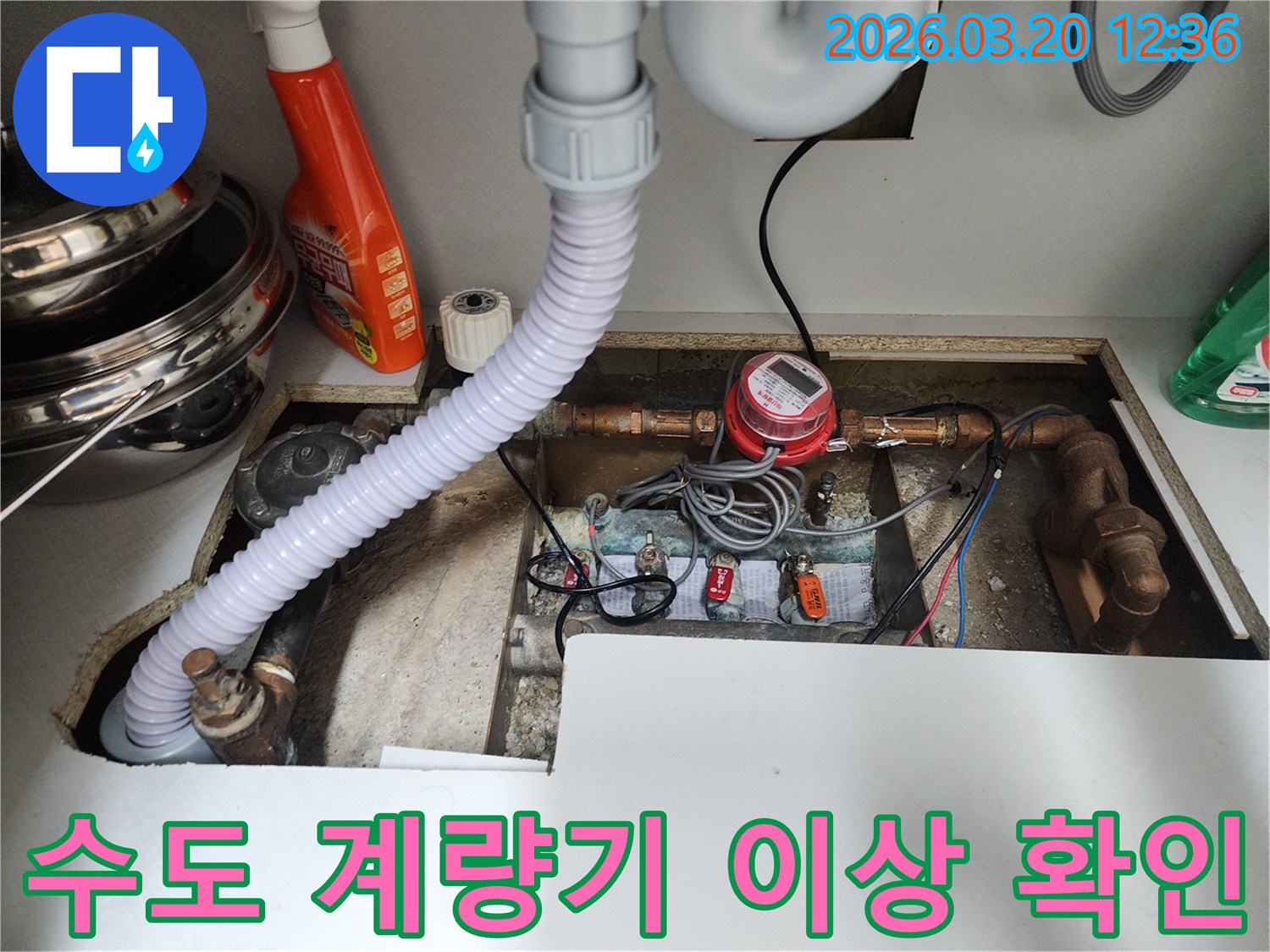 싱크대 아래-설치된-수도 계량기의-작동-상태와-주변-누수-징후를-면밀히-살펴보는-과정입니다