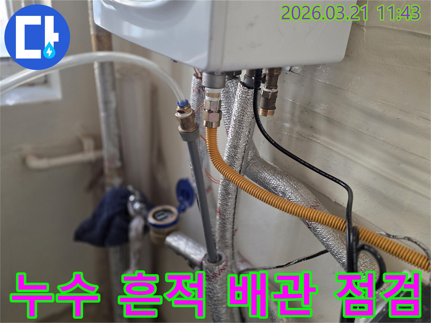 보일러 배관 주변에서 발견된-누수 흔적을 정밀하게 점검하는-전문가의 모습입니다.