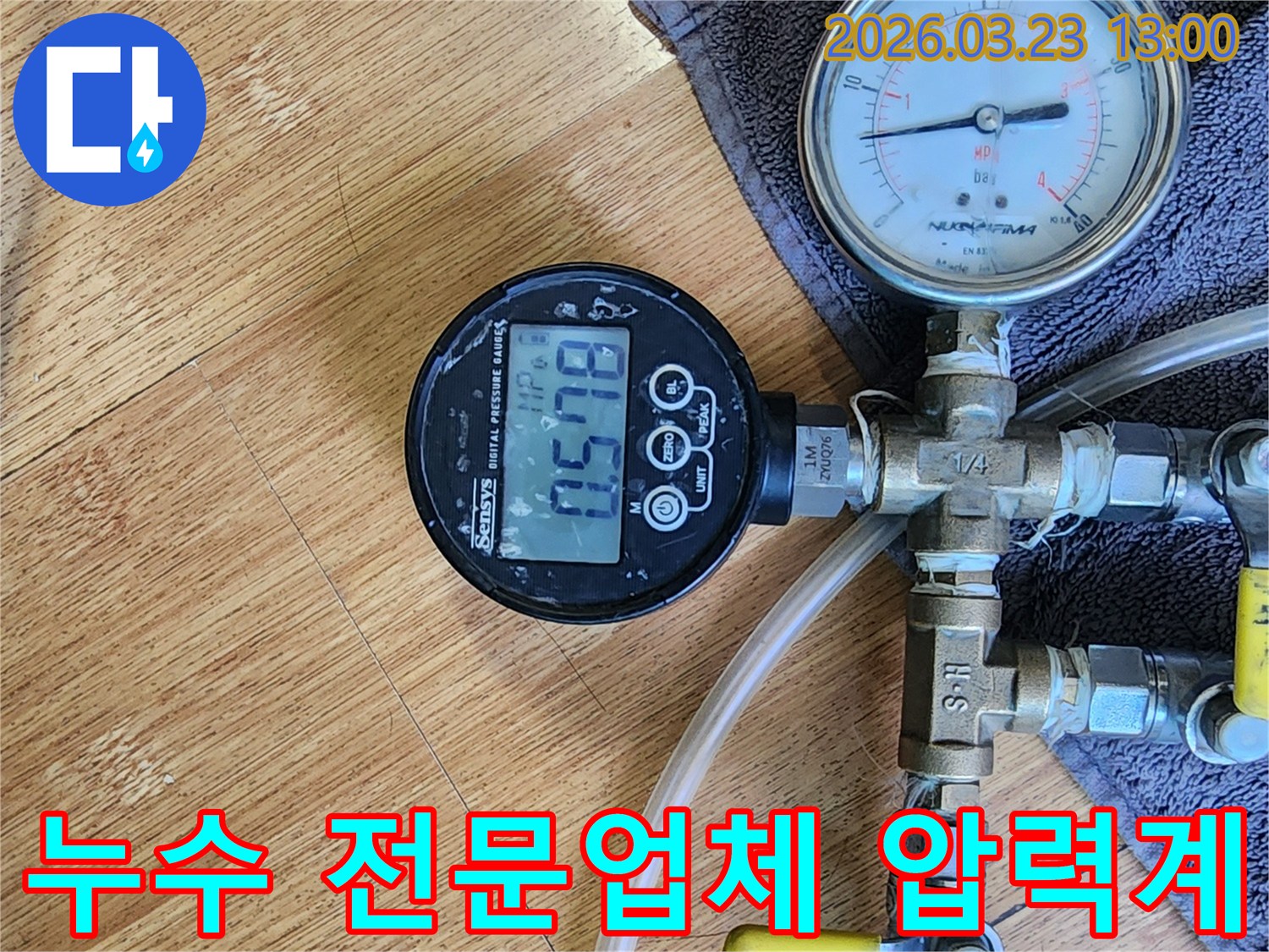누수 탐지 전문 업체가 사용하는-정밀한 디지털 압력계가 배관에 연결되어-현재 압력 수치를 정확하게 측정하고 있습니다.