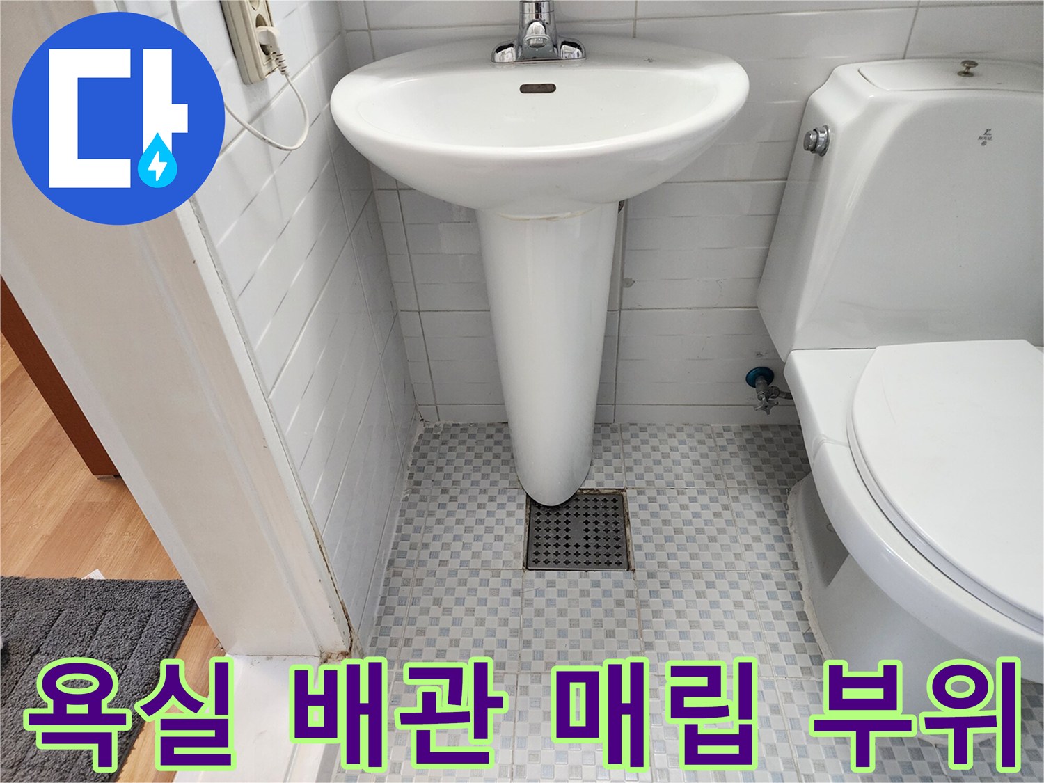 변기 뒤쪽 타일 벽면과 배수구 입구 모습
