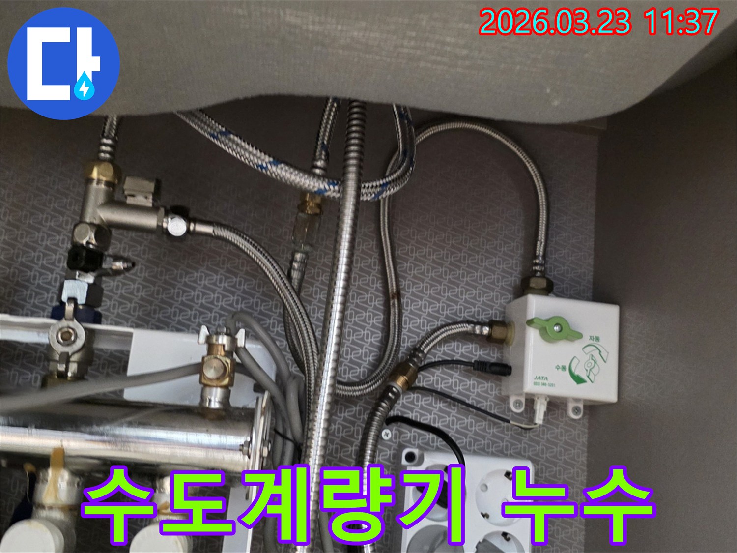 싱크대 하부장 내부의 수도-계량기-연결부와 정수기-밸브-수도-호스-배관-전기 콘센트가-보이는 곳에서-누수 흔적을-찾아내고 있습니다.