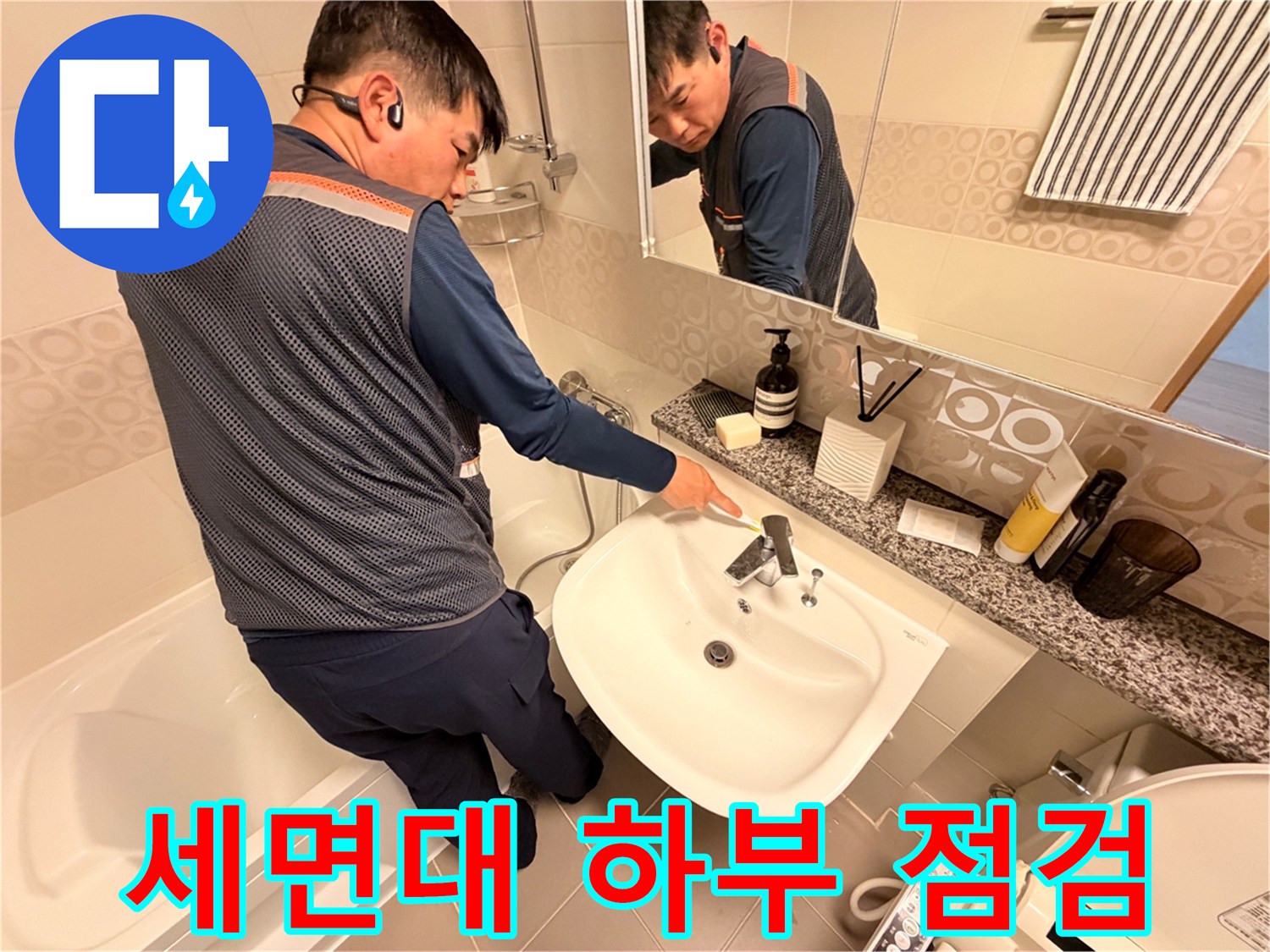 욕실 세면대 아래쪽-배관과 수전 연결 부위를 점검하는 작업자