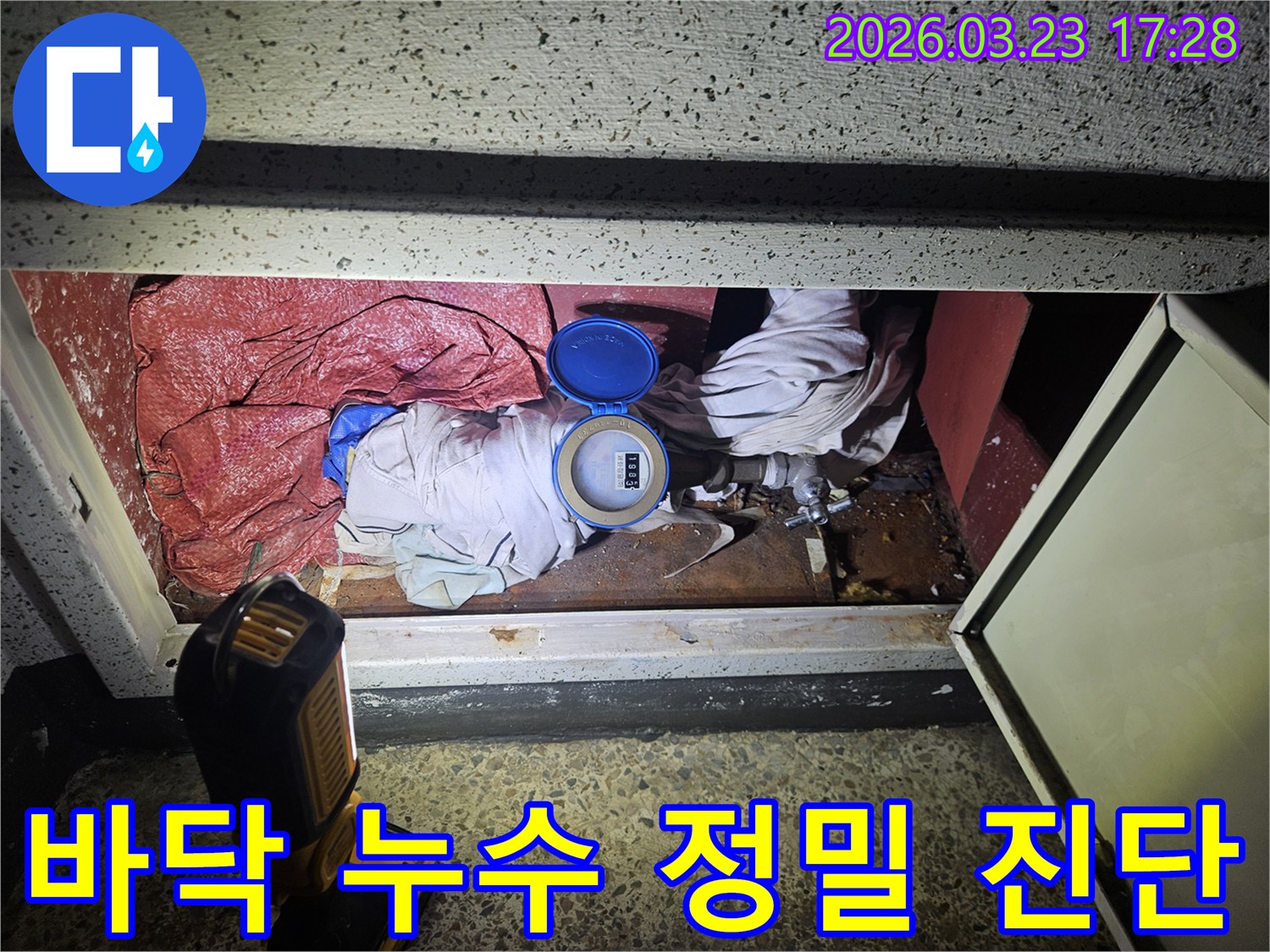 수도 계량기 덮개를 열고 내부 상태를 점검하며 누수 지점을 파악하는 작업