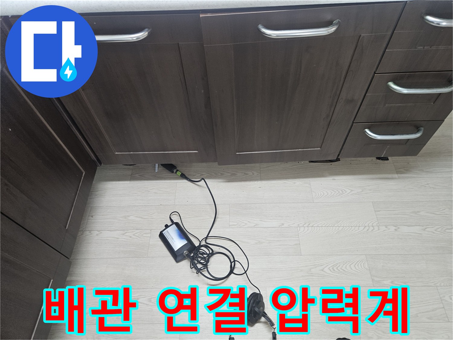 싱크대 아래 배관에 설치된 공압 테스트용 디지털 장비 모습