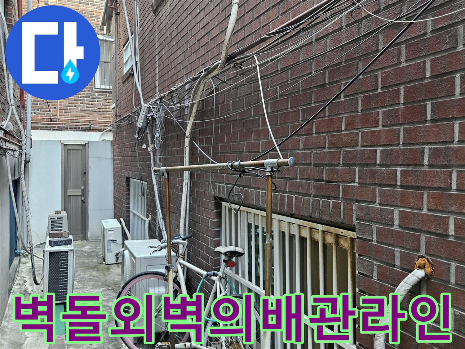 붉은-벽돌-건물-외부에-설치된-다양한-유틸리티-배관들
