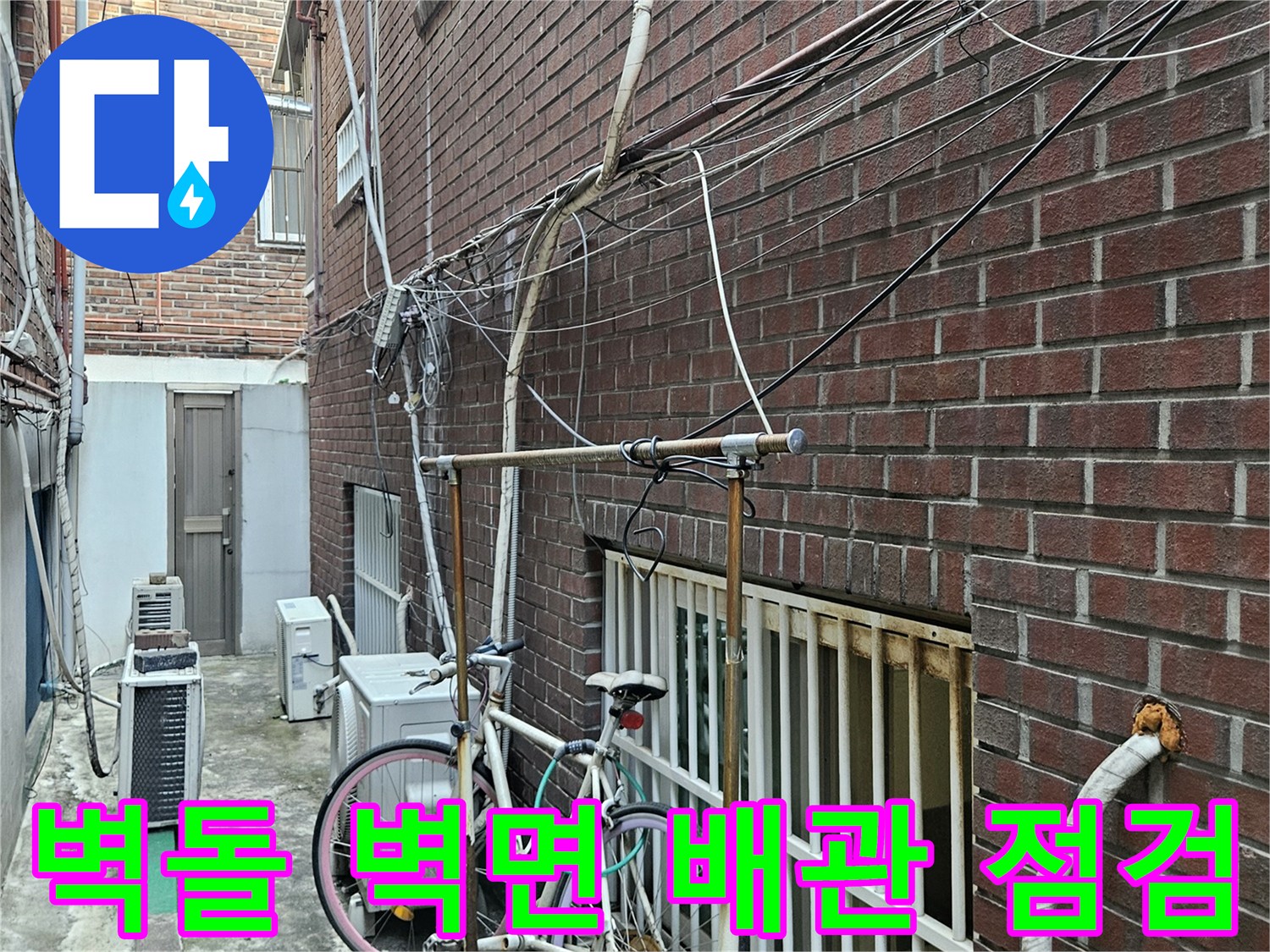 붉은 벽돌 외벽-외부에 설치된 각종 배관과 선로들