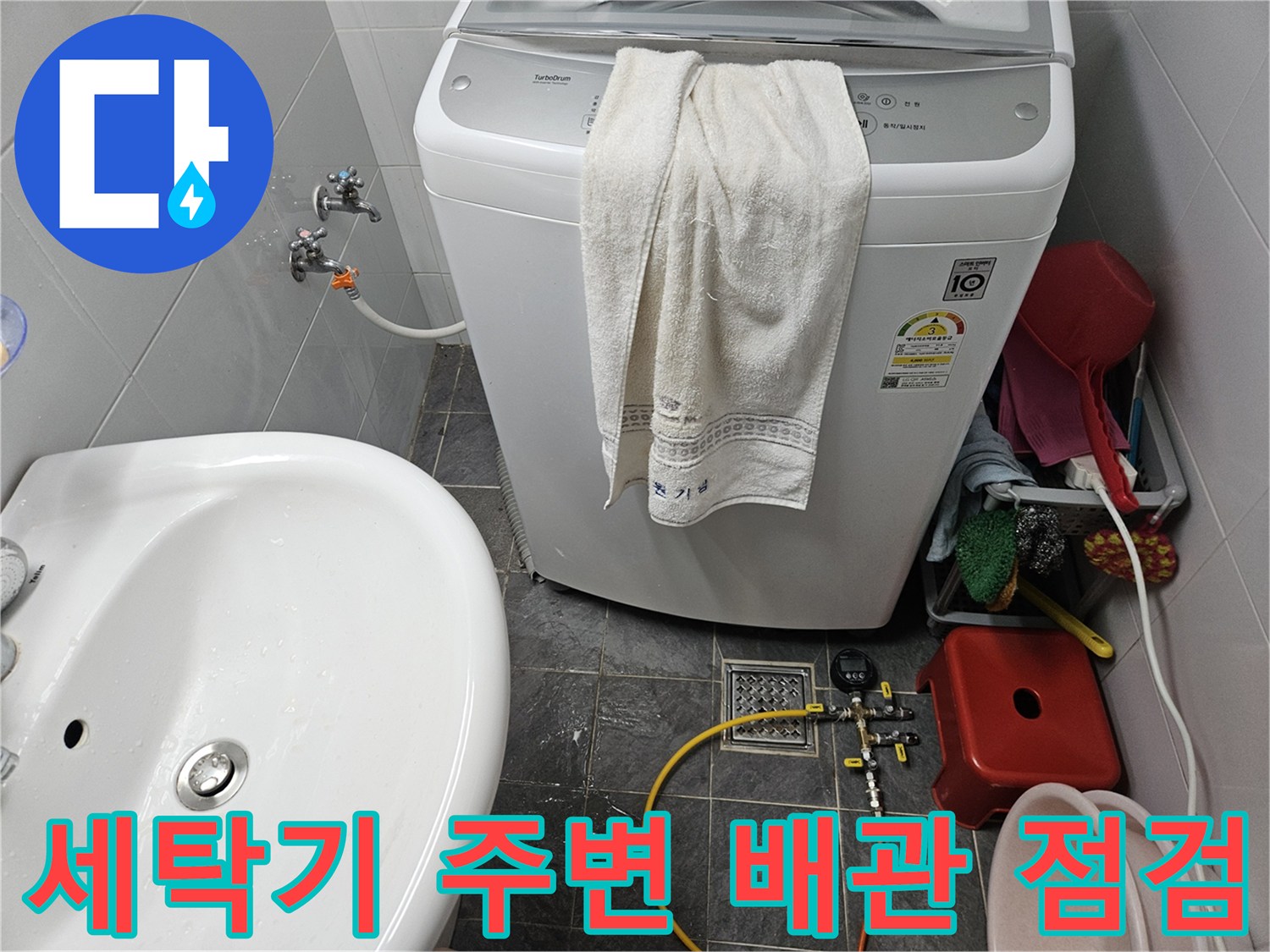 세탁기 근처 수도 배관에 디지털 압력계를 연결하여 정밀 진단 중인 모습