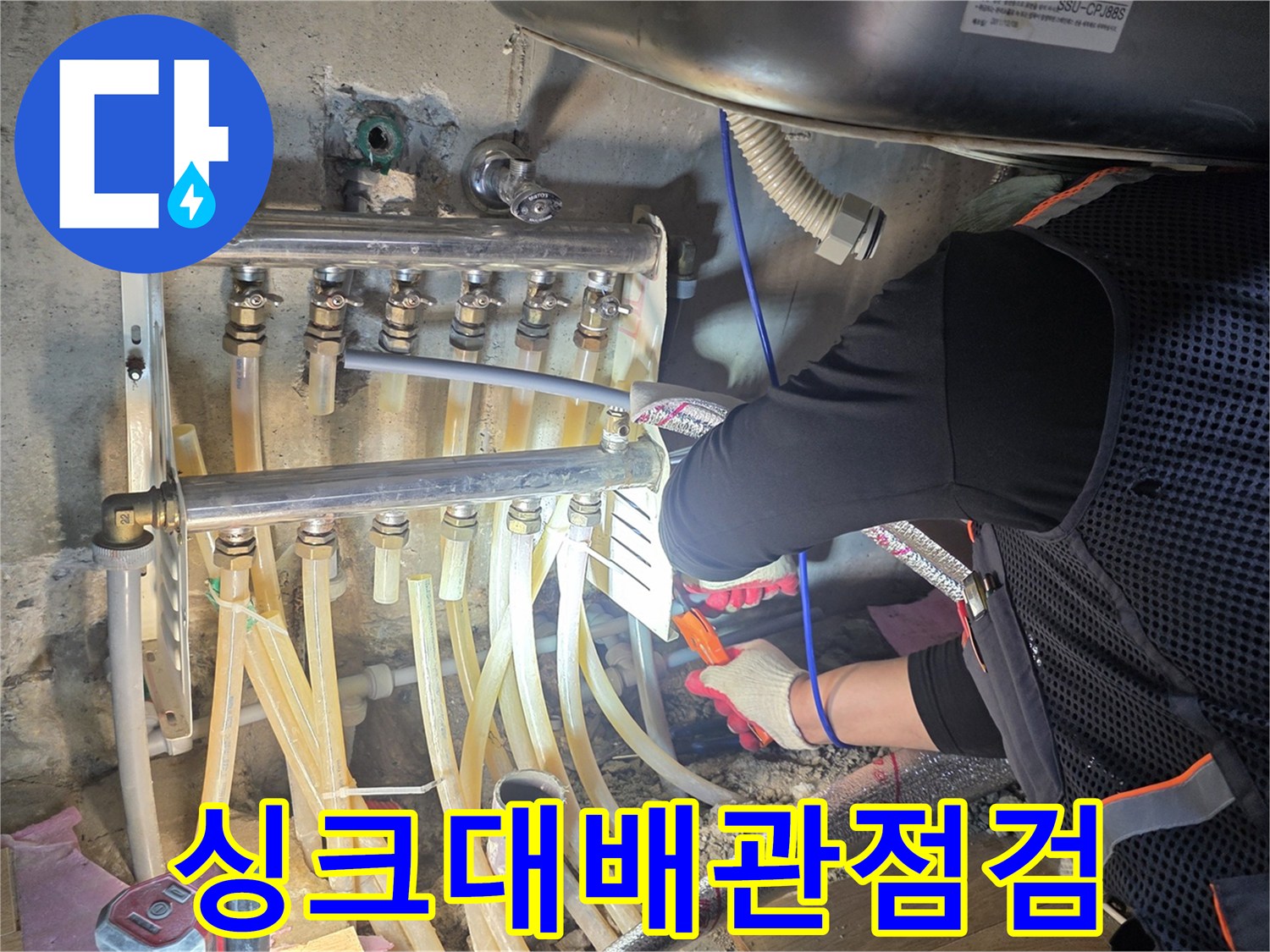 싱크대 하단부 분배기와 연결된 배관들을 점검하는 모습입니다.