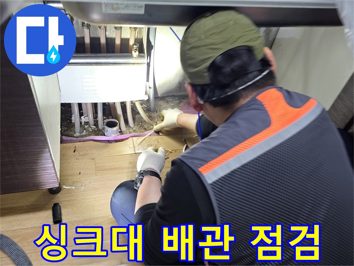 작업자가-싱크대-하단-배관을-면밀히-살피는-장면