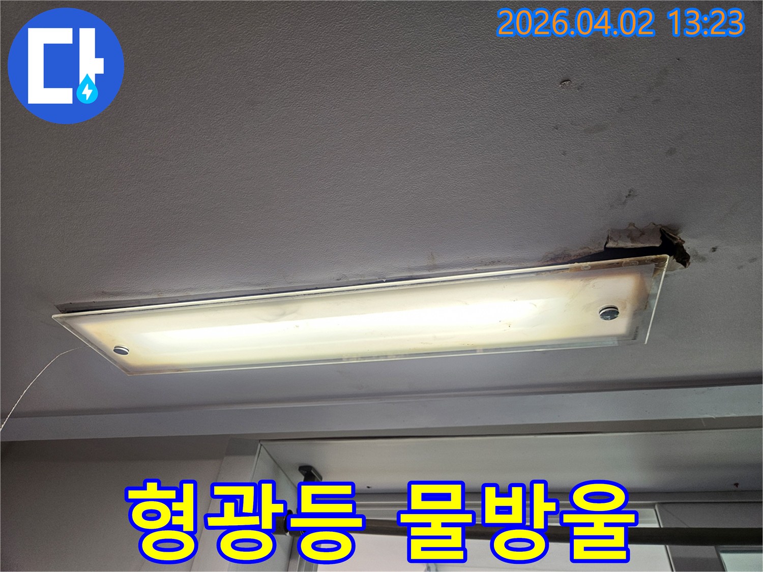 상가 천장 형광등에서 물방울이 떨어지는 심각한 누수 현장과 긴급 점검이 필요한 상황을 보여주는 이미지
