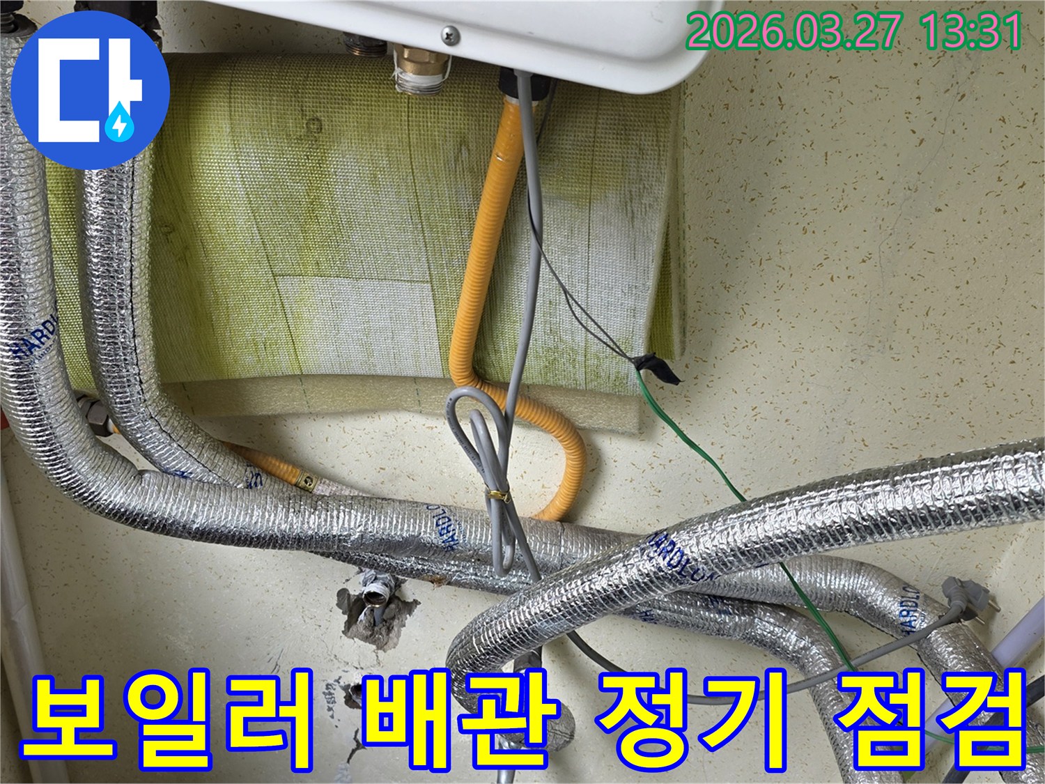 보일러-하단에-연결된-배관과-전선이-복잡하게-얽혀있는-모습을-보여주며-누수-예방을-위한-정기적인-배관-점검-과정입니다.
