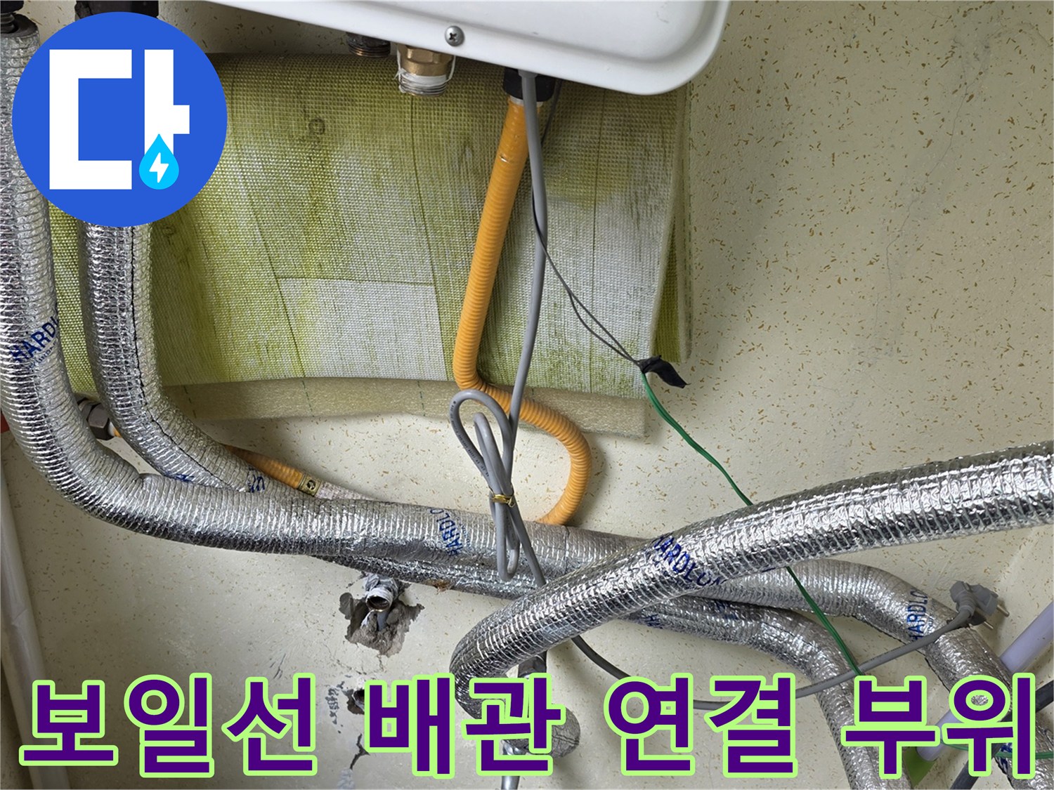 은박 소재 단열재로 감싸진-보일러 아래쪽의 복잡한 배관 구조