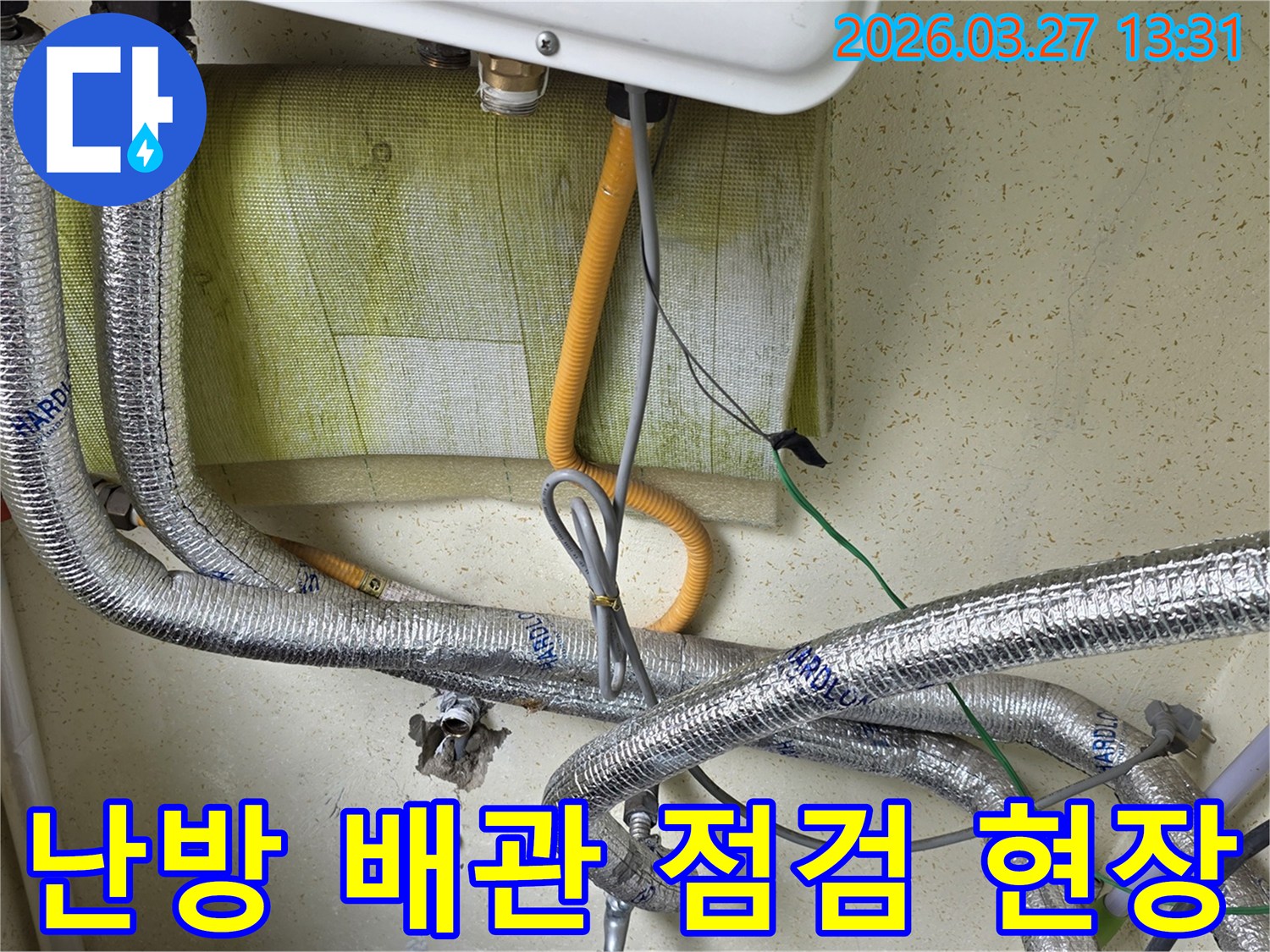 은색-단열재로-감싸진-난방-배관과-다른-배관들이-얽혀있는-보일러-하단부의-모습을-보여주며-겨울철-누수-탐지를-위한-점검-과정입니다.