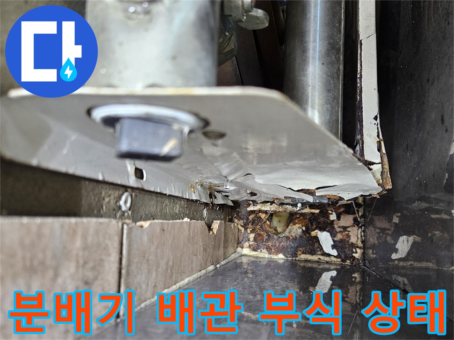 보일러 분배기 하단 - 배관 연결부의 심한 부식과 물샘 흔적을 보여주는 사진입니다.