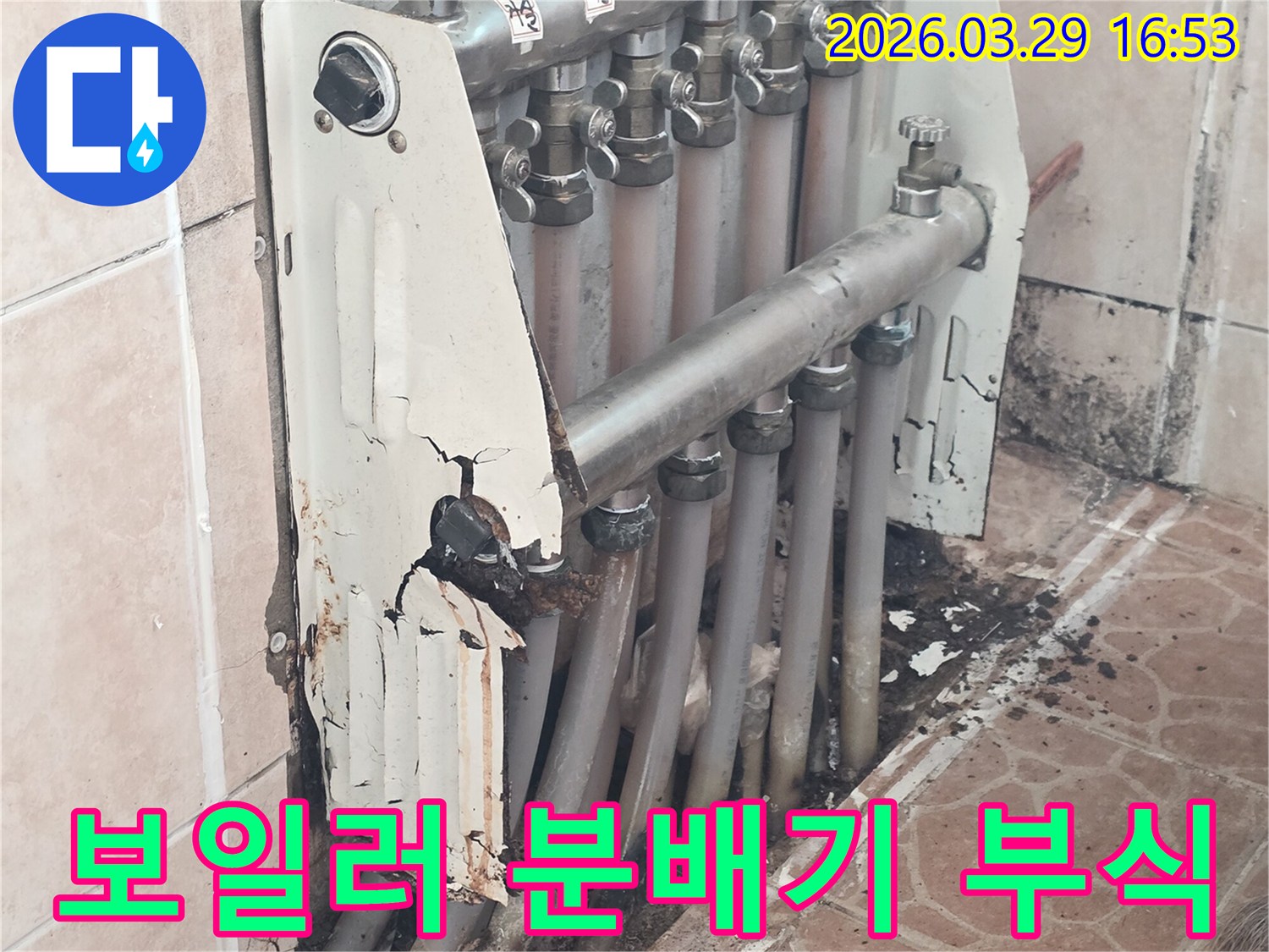 이 이미지는 심하게 부식되고 파손된 보일러 분배기 주변을 보여주며-이는 장기적인 누수 문제의 명확한 증거입니다.