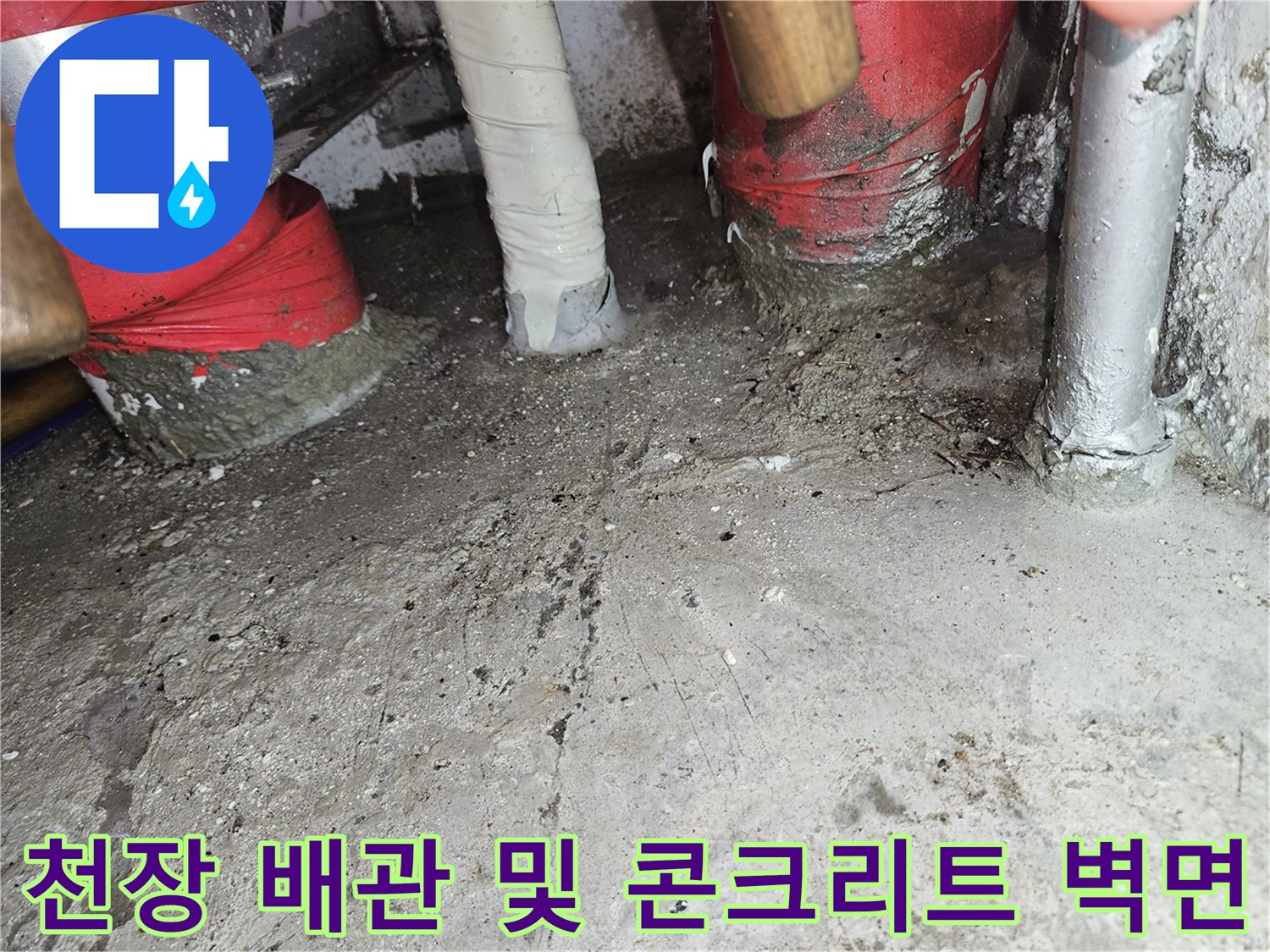 설비실 내부의 붉은색 보온재 배관과 거친 콘크리트 천장 표면 촬영
