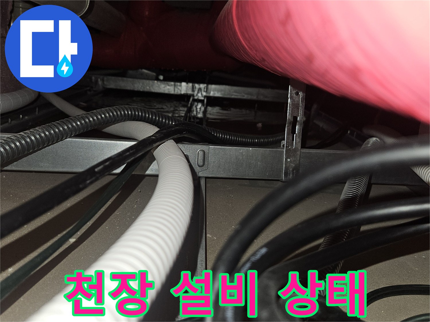 하얀색-배수-호스와-전기-배선이-얽힌-천장-내부