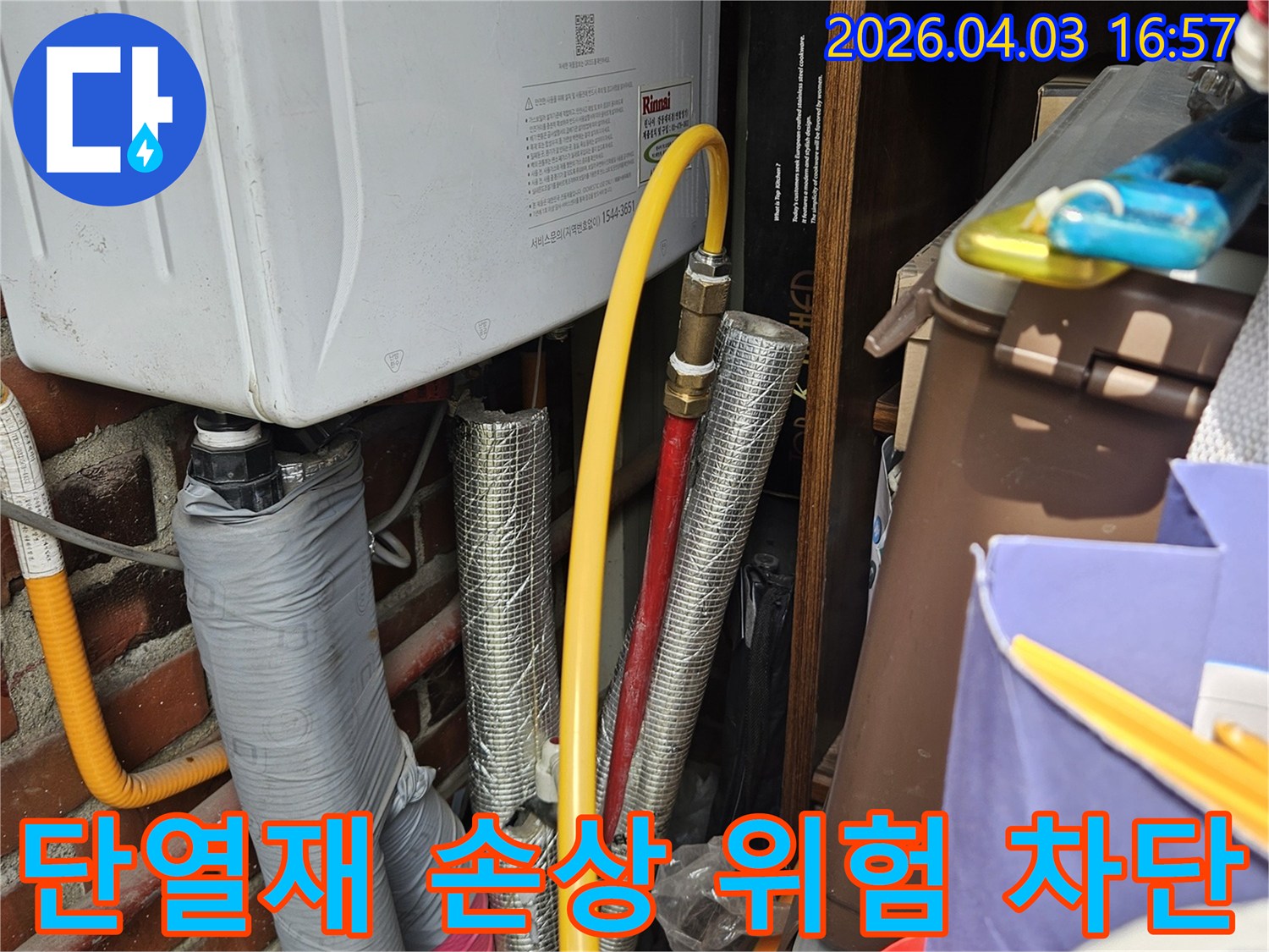 보일러 옆에 위치한 가스 배관과 단열 처리된 온수 배관의 연결 부위를 근접 촬영한 이미지입니다-미세한 누수 지점을 찾기 위한 정밀 검사 과정입니다.