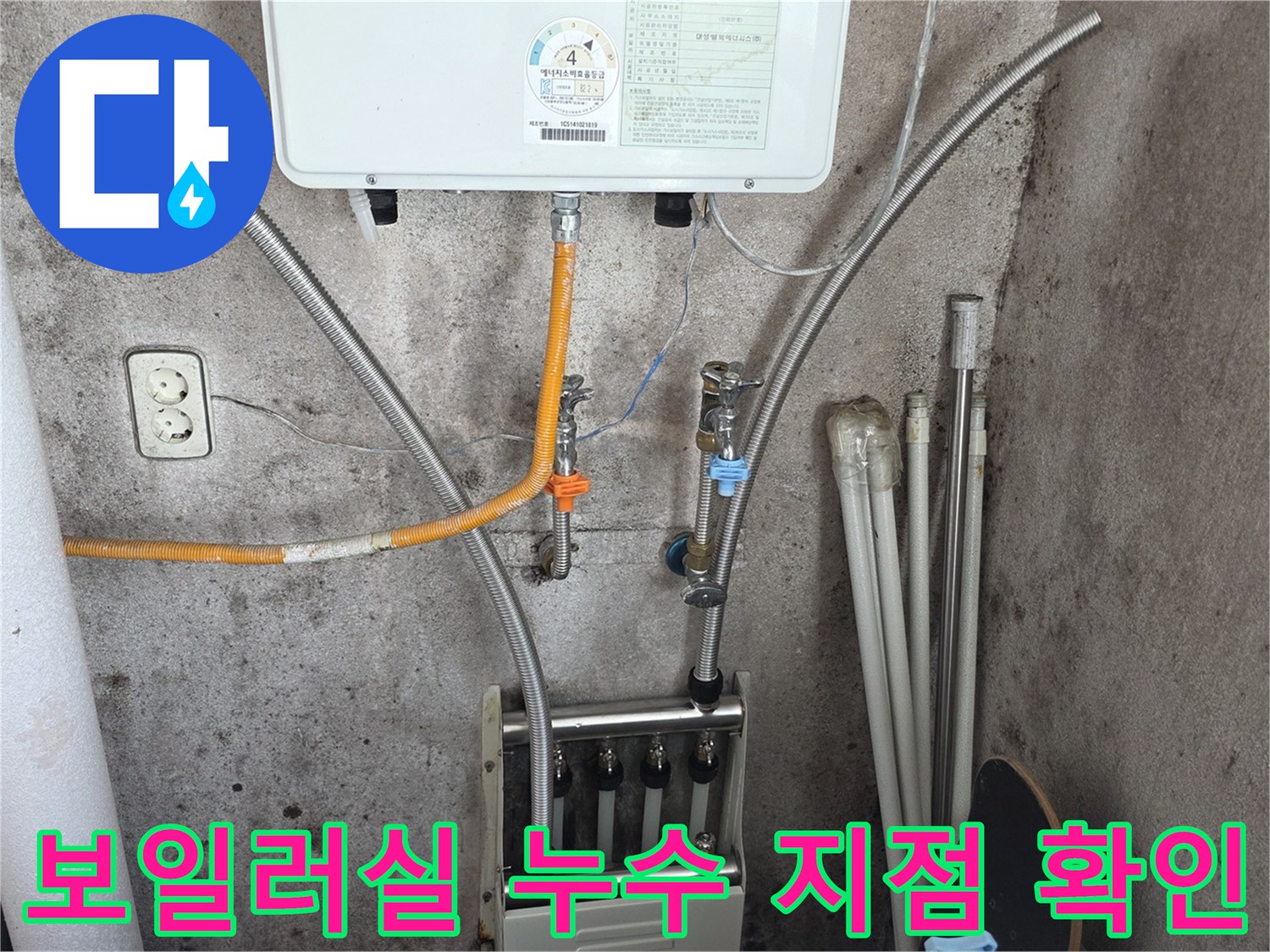 보일러 본체 아래 연결된 은색 배관과 밸브 모습