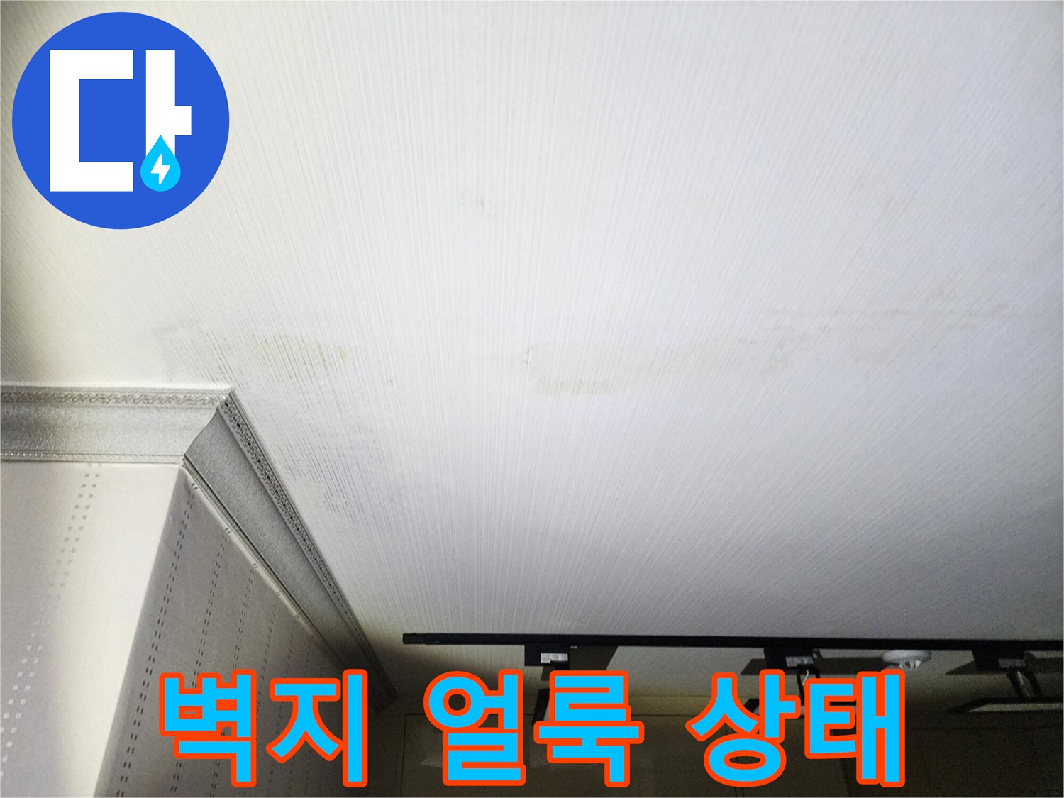 천장 벽지에 발생한 거뭇한 물 얼룩과 습기 흔적