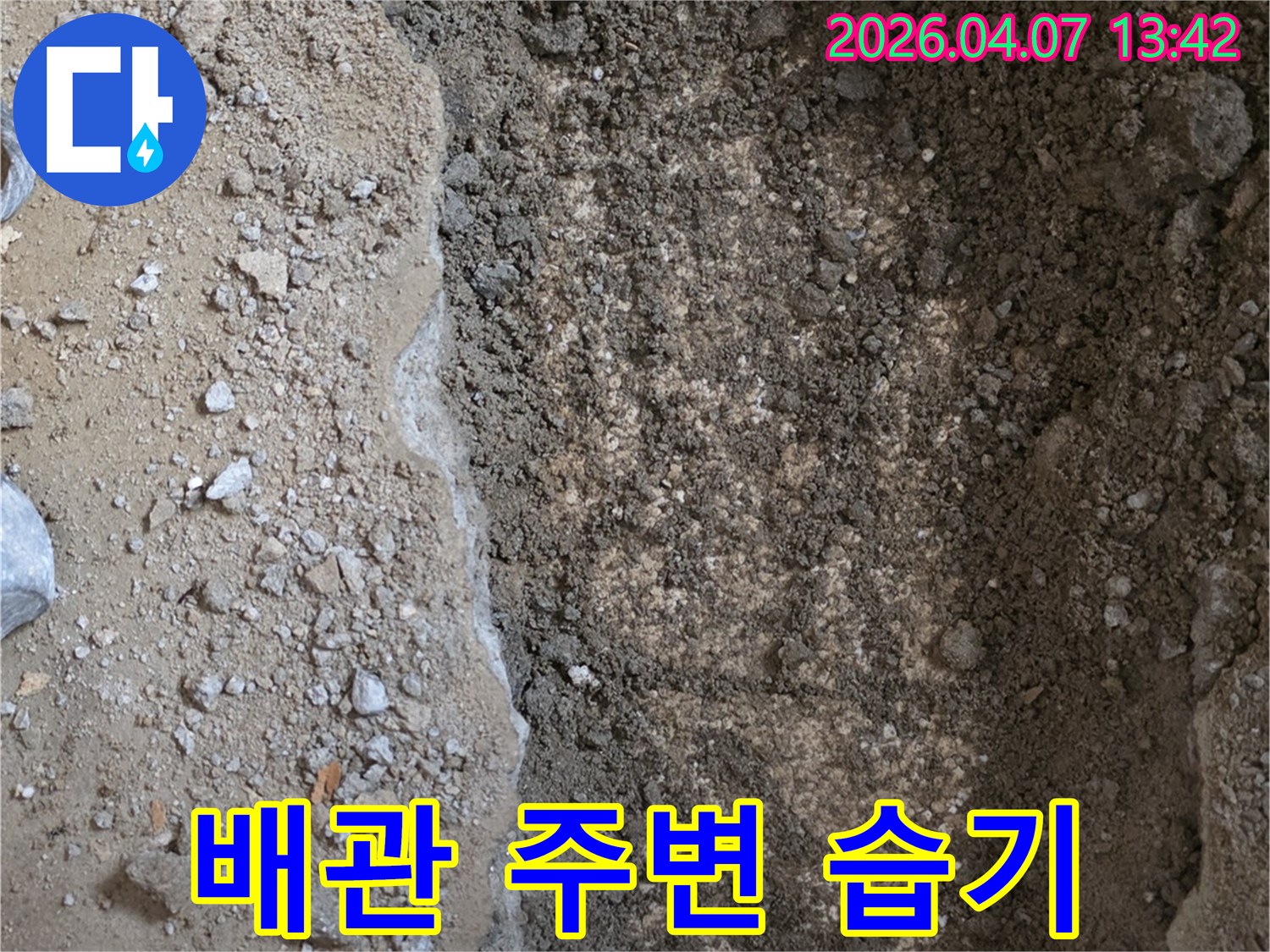 누수-탐지-현장에서-땅을-파내어-드러난-배관-주변의-습기-머금은-흙을-보여주는-이미지