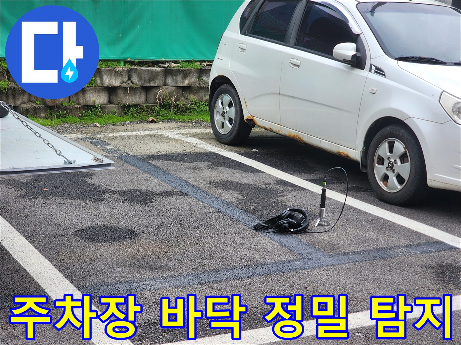 양평 옥천면 주차장 아스팔트 바닥에서 정밀 누수 탐지 장비를 사용하여 지점을 확인하는 모습