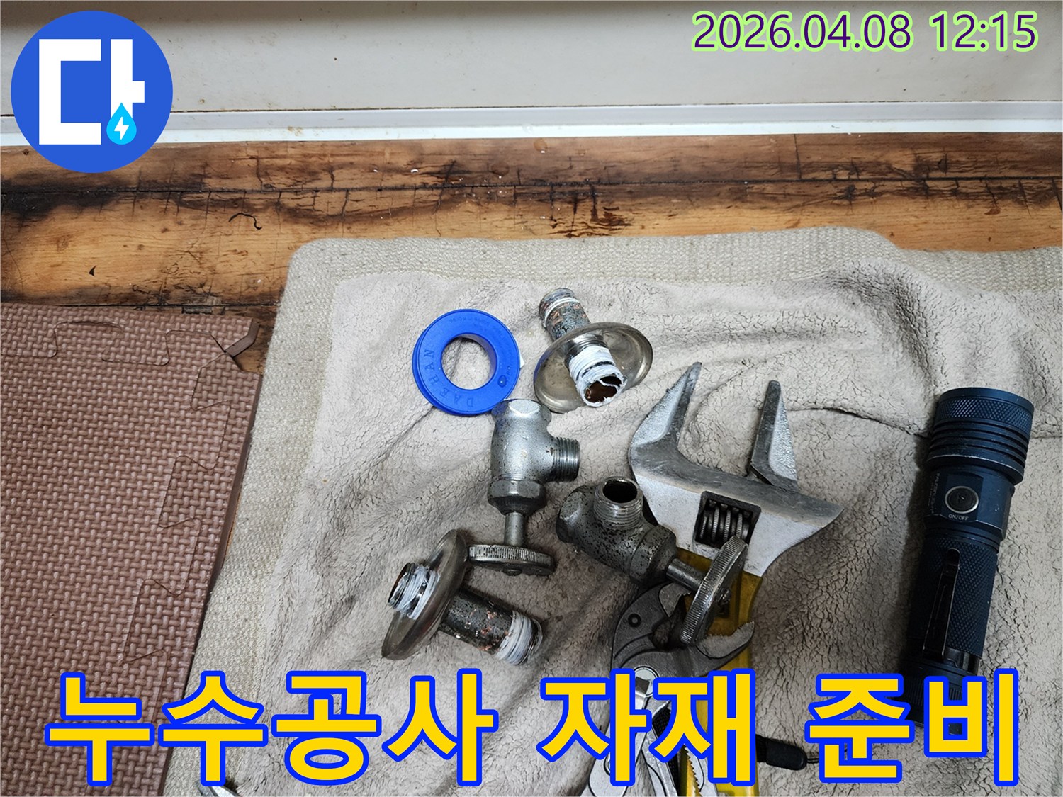 누수 공사 작업을 위해-준비된 다양한 자재와-전문 공구들이-수건 위에 깔끔하게 놓여있습니다