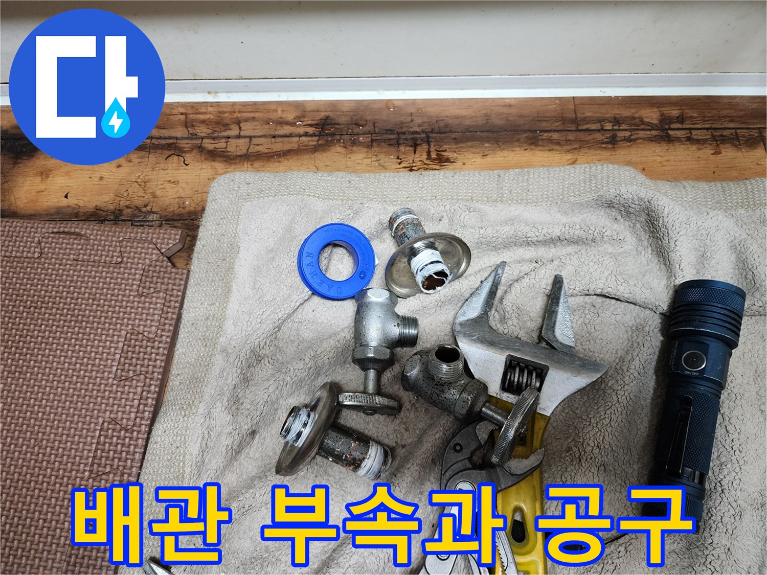 누수 점검을 위한 수도 부속품과 몽키스패너 및 손전등