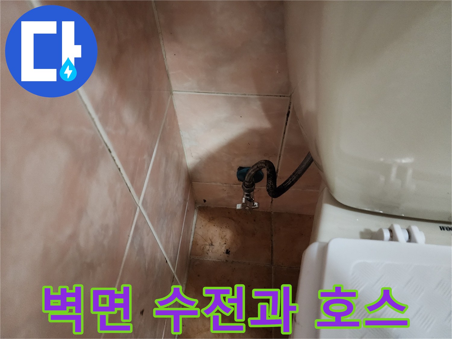 베란다 벽면에 설치된 수도꼭지와 검은색 배관 호스의 연결 모습입니다.
