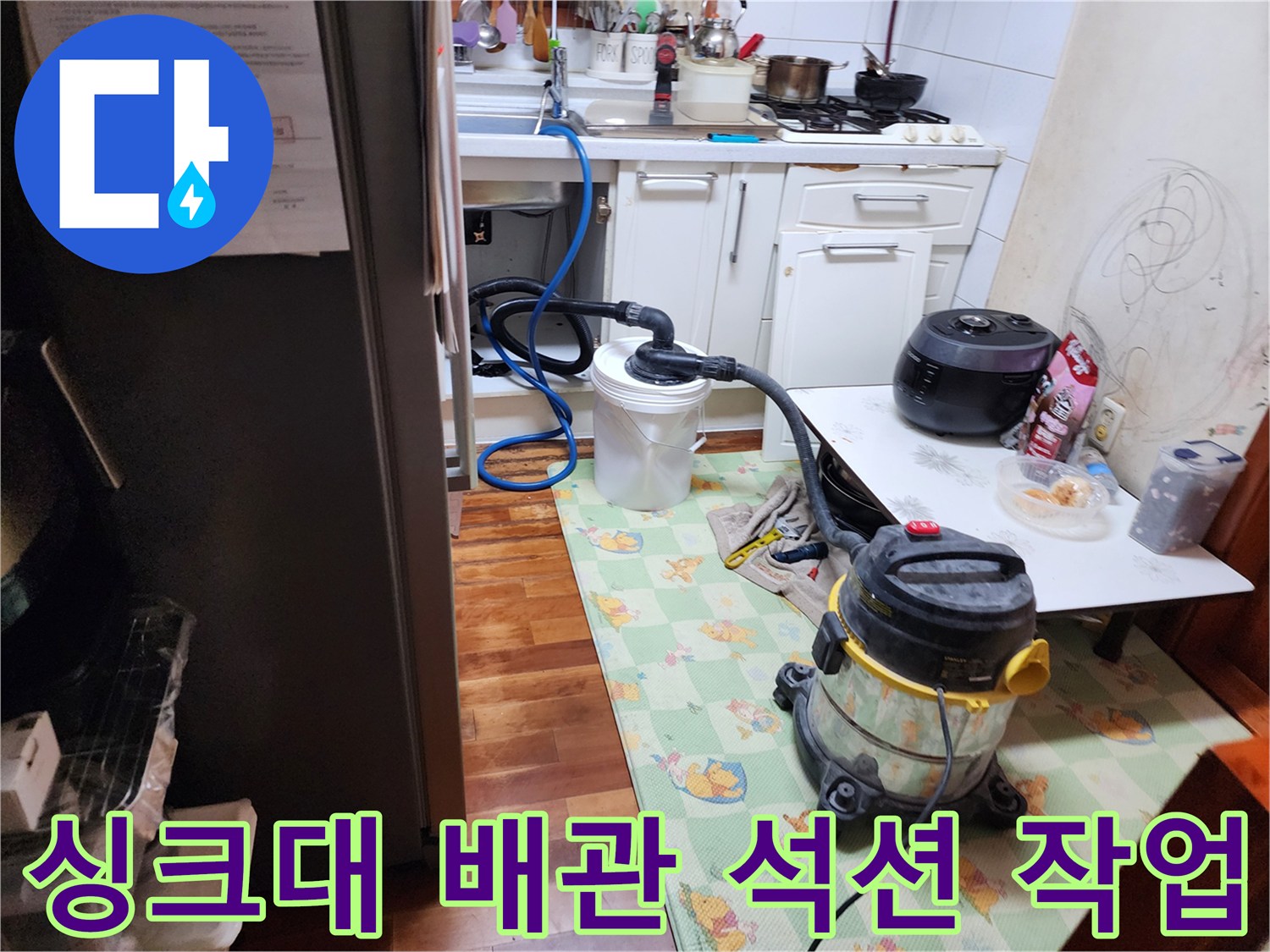 주방 싱크대 하수구 내부 이물질을 제거하기 위해 석션 장비를 사용하는 모습