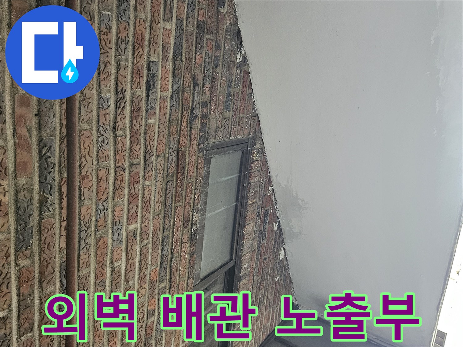 건물 외벽의 적벽돌 구조와 설치된 배관 라인을 보여주는 사진입니다.