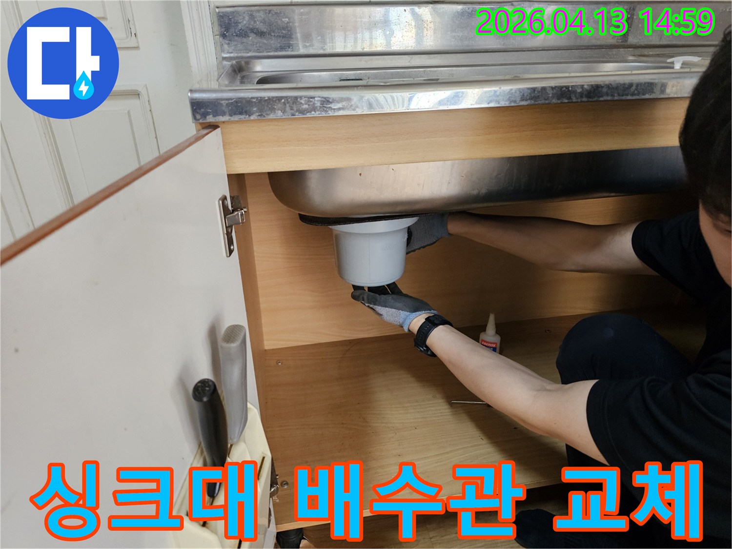 엔지니어가 싱크대 하부에서-오래된 배수관을 새것으로 교체하고 있습니다.