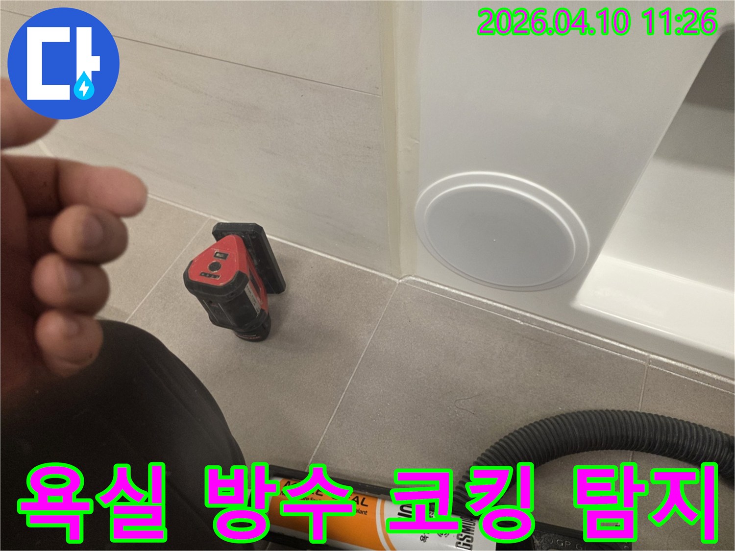 욕실 타일 바닥과 벽면의 경계에-누수 방지를 위한-실리콘 코킹 작업 준비 및-탐지 장비가 놓인 현장