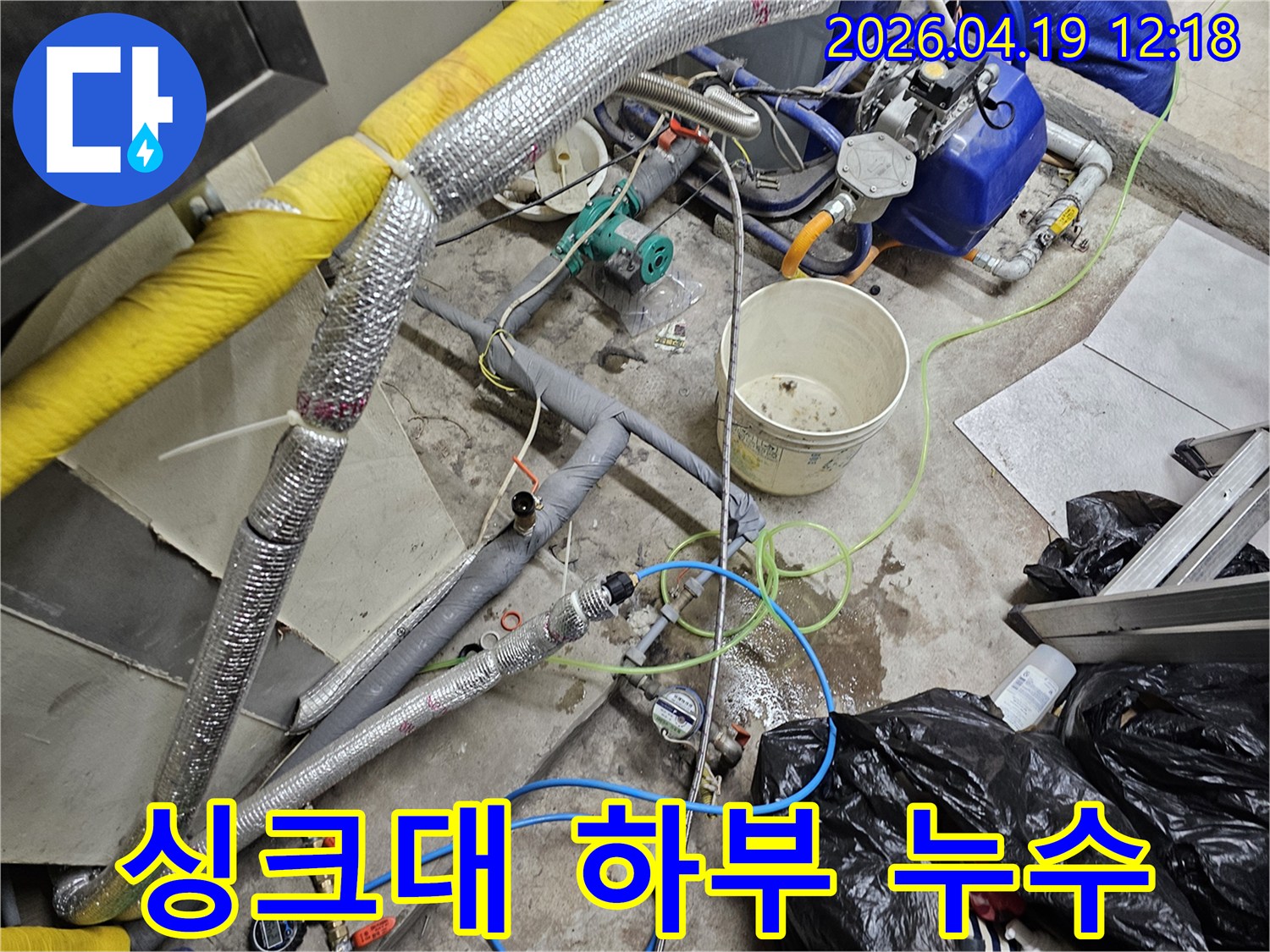 물이 고인 바닥과-다양한 배관-그리고 탐지 장비들이-복잡하게 놓인-싱크대 하부 누수 현장