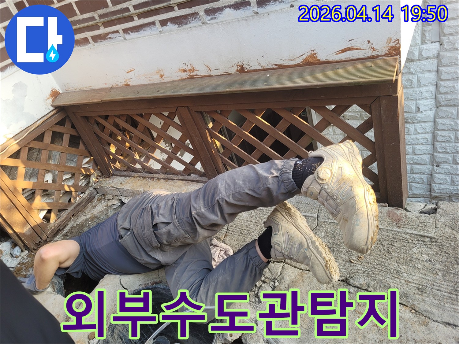 가평 운악청계로 인근 주택에서-외부 수도관 누수를 찾기 위해-엔지니어가 좁은 공간으로-몸을 넣어 탐지하는-집중적인 작업 현장