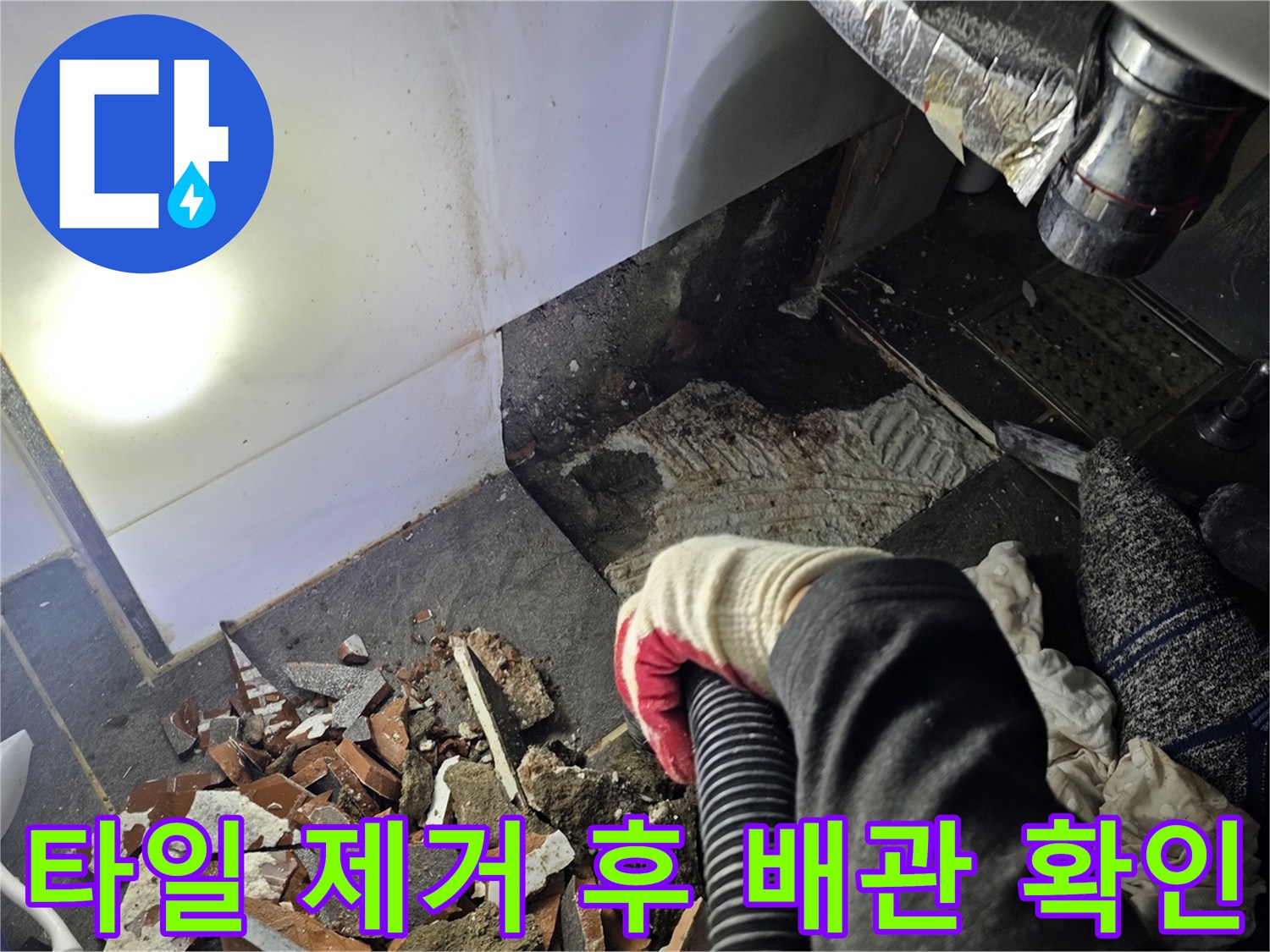 세면대 하단 타일을 컷팅하여 내부 배관을 노출시킨 작업 모습입니다.