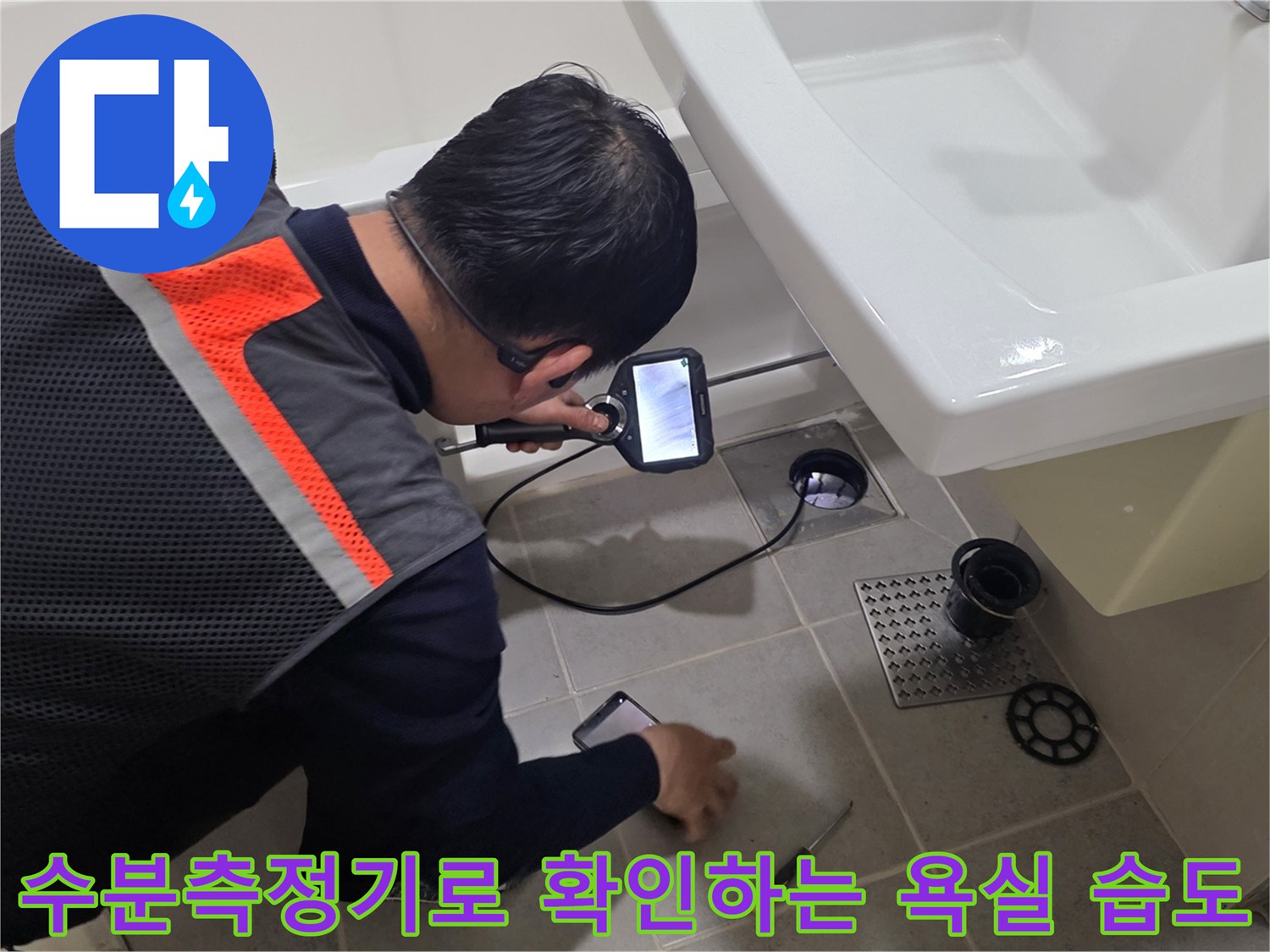 엔지니어가 수분측정기를 사용하여 욕실 바닥의 습도를 체크하고 있습니다.
