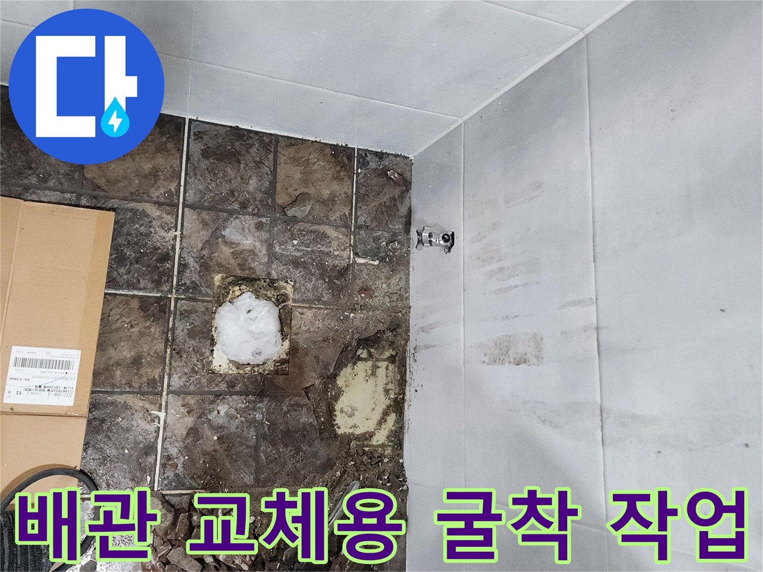 변기 뒤쪽 배관 수리를 위해 타일을 제거하고 바닥을 드러낸 모습